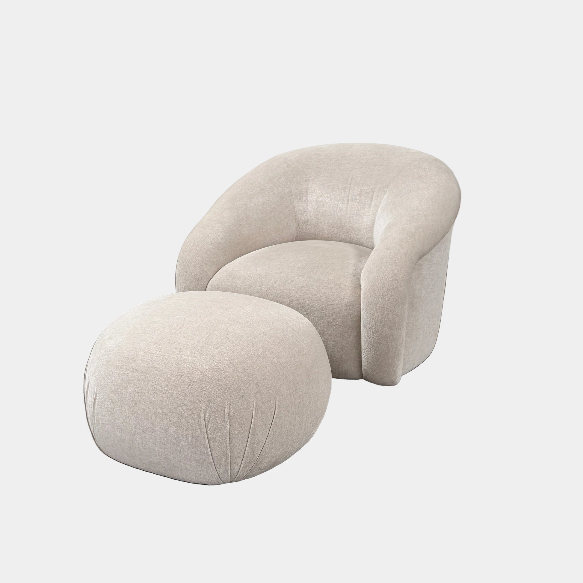 Certainly! Here’s a rewritten version of the sentence using your product data: The Vintage Chair + Ottoman – In The Style of Steve Chase by Vintage, featuring beige upholstery with rounded edges and a matching oval ottoman, both set against a plain white background, evoke the timeless elegance of mid-century modern furniture.