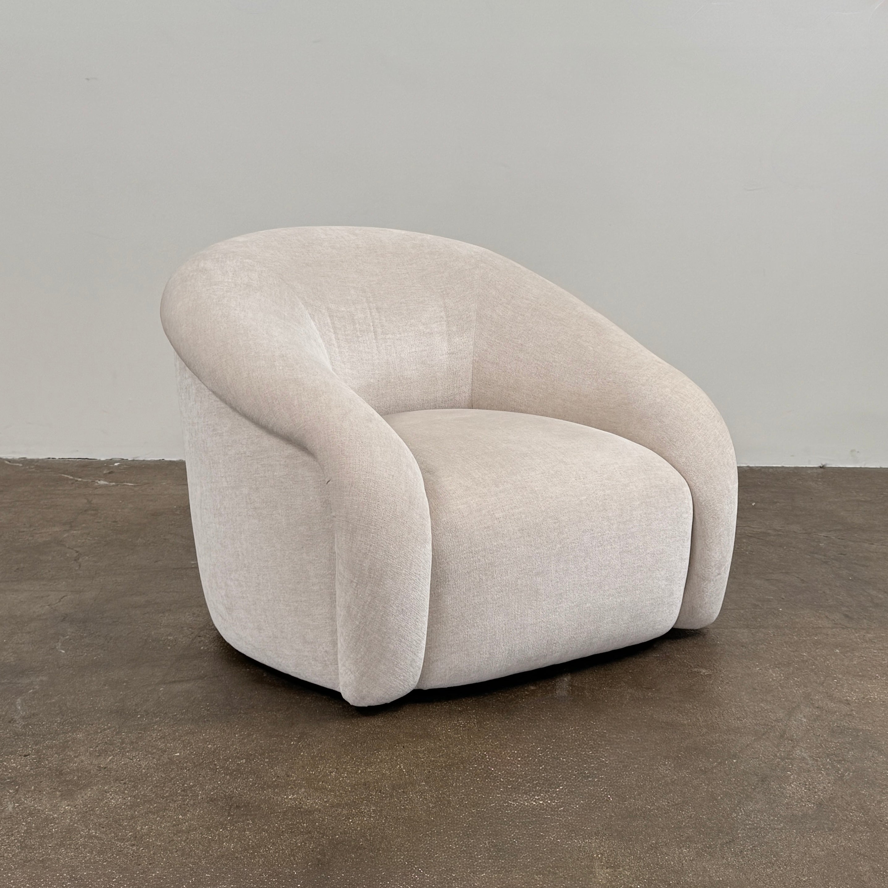 Certainly! Here’s a rewritten version of the sentence using your product data: The Vintage Chair + Ottoman – In The Style of Steve Chase by Vintage, featuring beige upholstery with rounded edges and a matching oval ottoman, both set against a plain white background, evoke the timeless elegance of mid-century modern furniture.