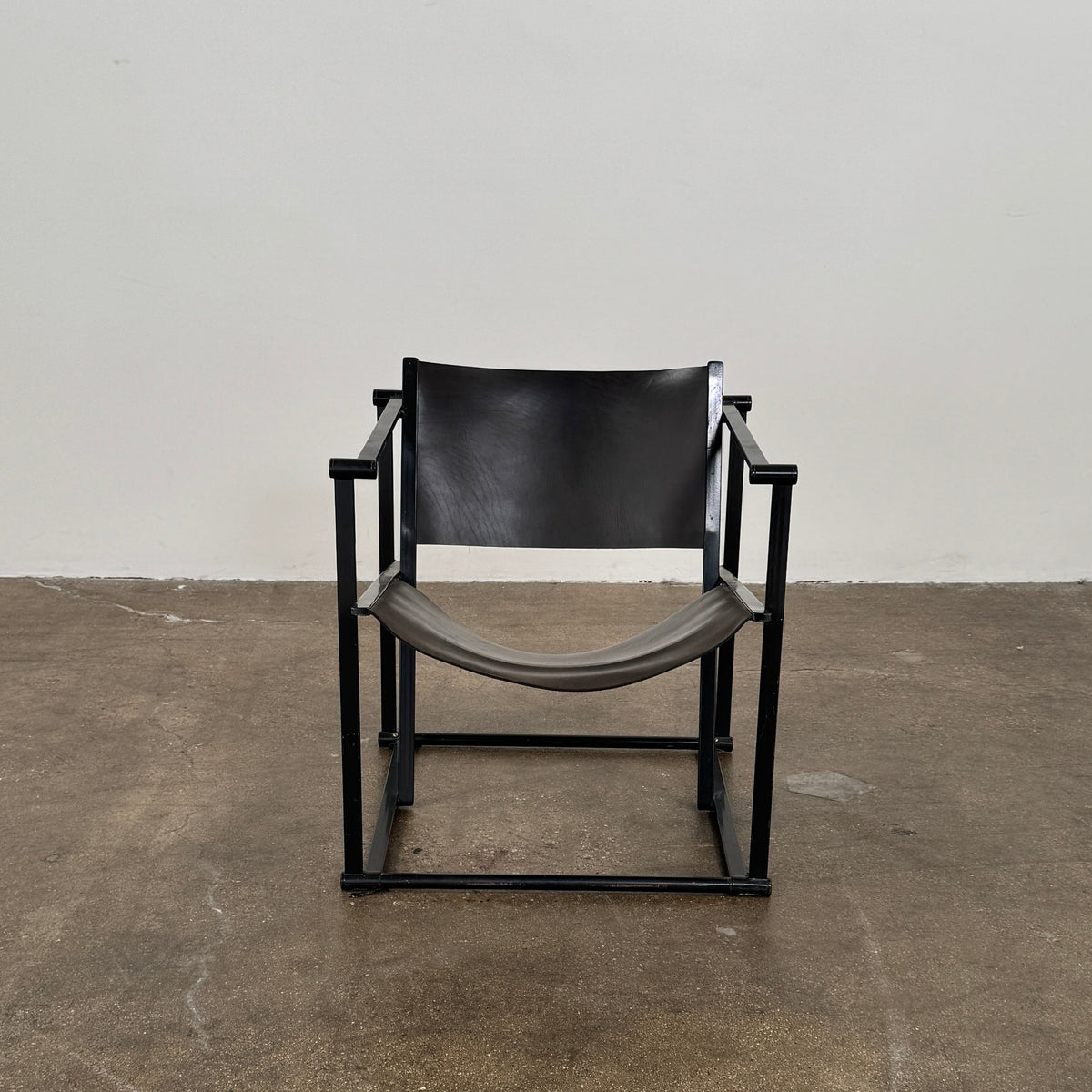 Two black Vintage Pastoe FM62 Chairs by Pastoe, inspired by constructivist design, are placed on a tile floor in a spacious, minimal living room with large windows overlooking a pool and greenery outside.
