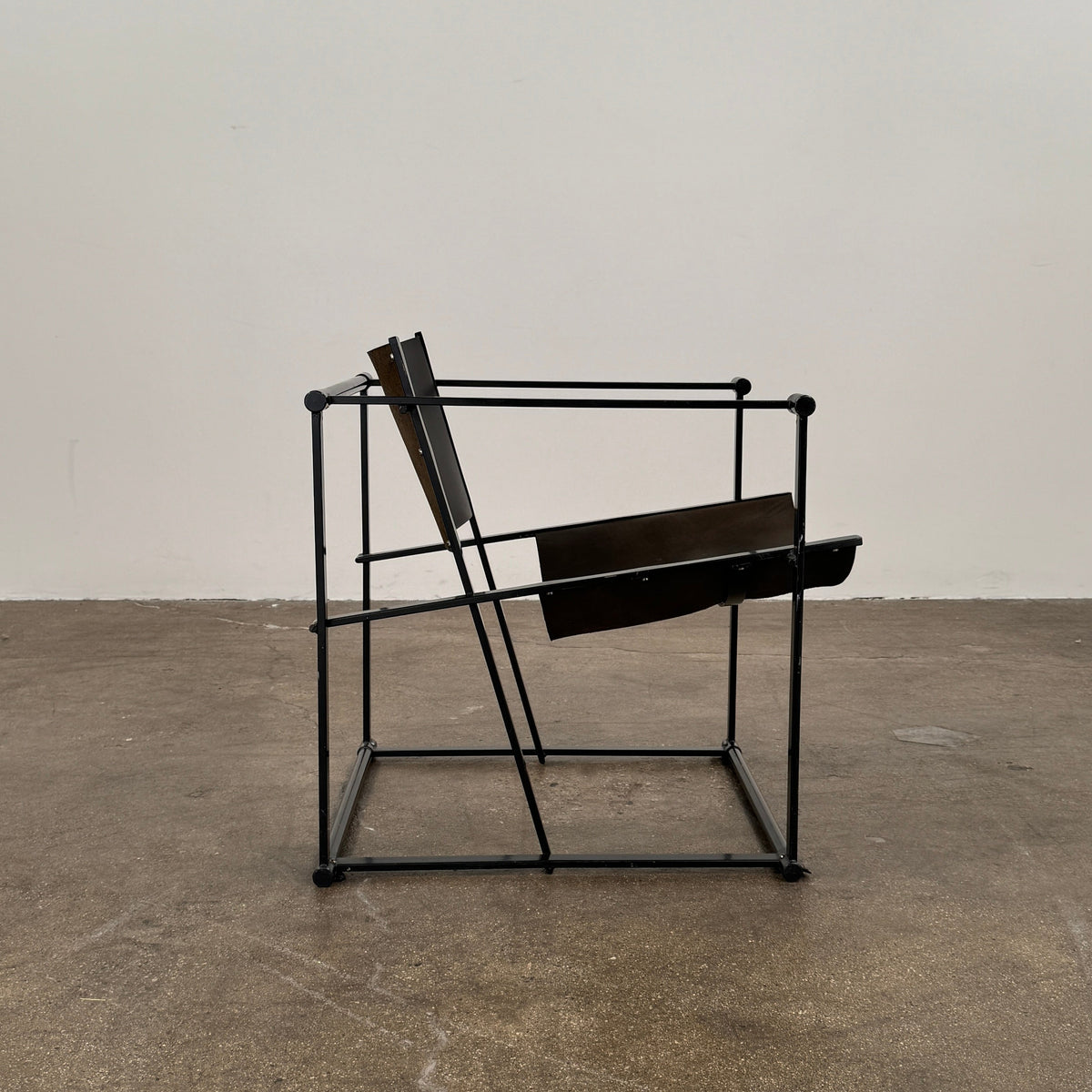 Two black Vintage Pastoe FM62 Chairs by Pastoe, inspired by constructivist design, are placed on a tile floor in a spacious, minimal living room with large windows overlooking a pool and greenery outside.