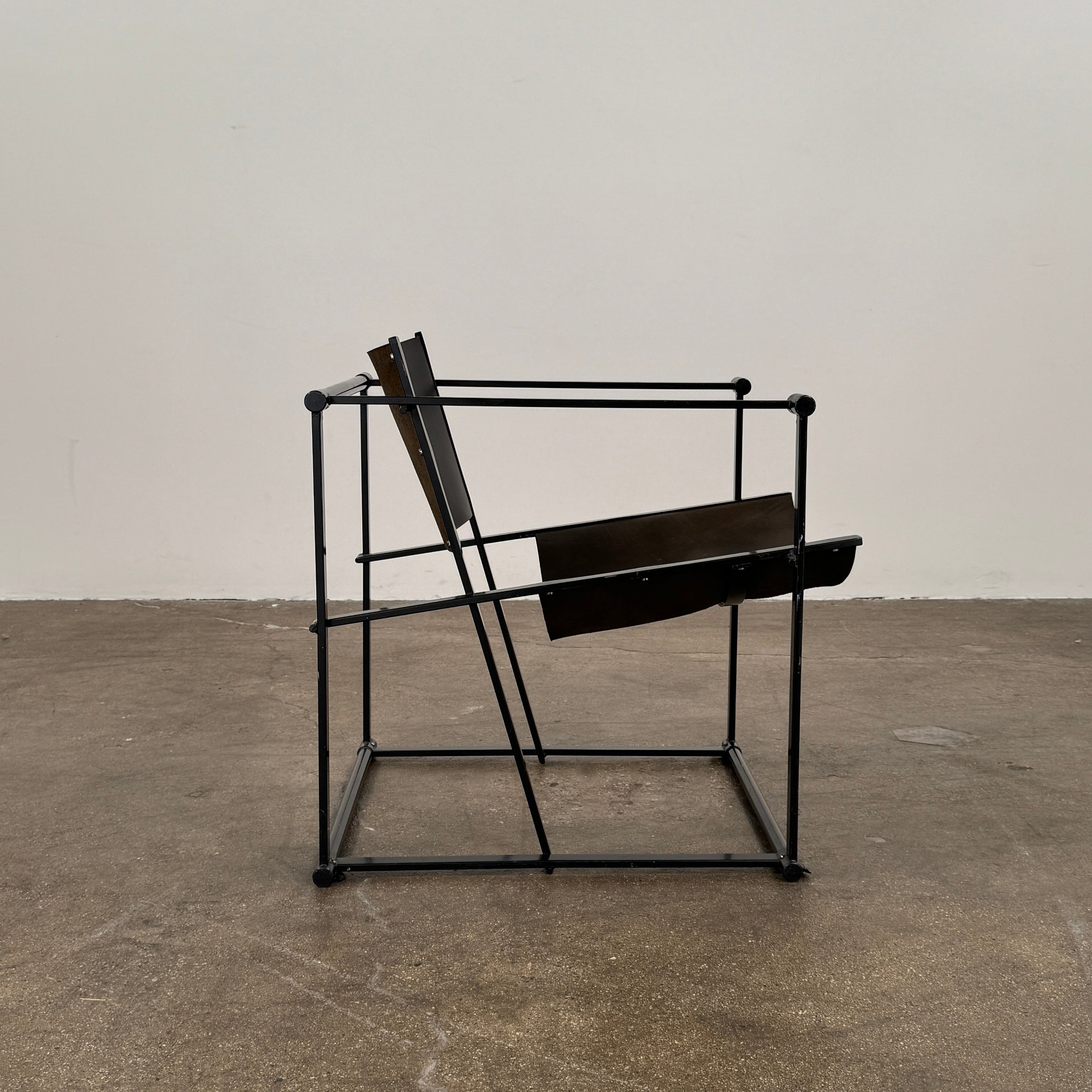 Two black Vintage Pastoe FM62 Chairs by Pastoe, inspired by constructivist design, are placed on a tile floor in a spacious, minimal living room with large windows overlooking a pool and greenery outside.