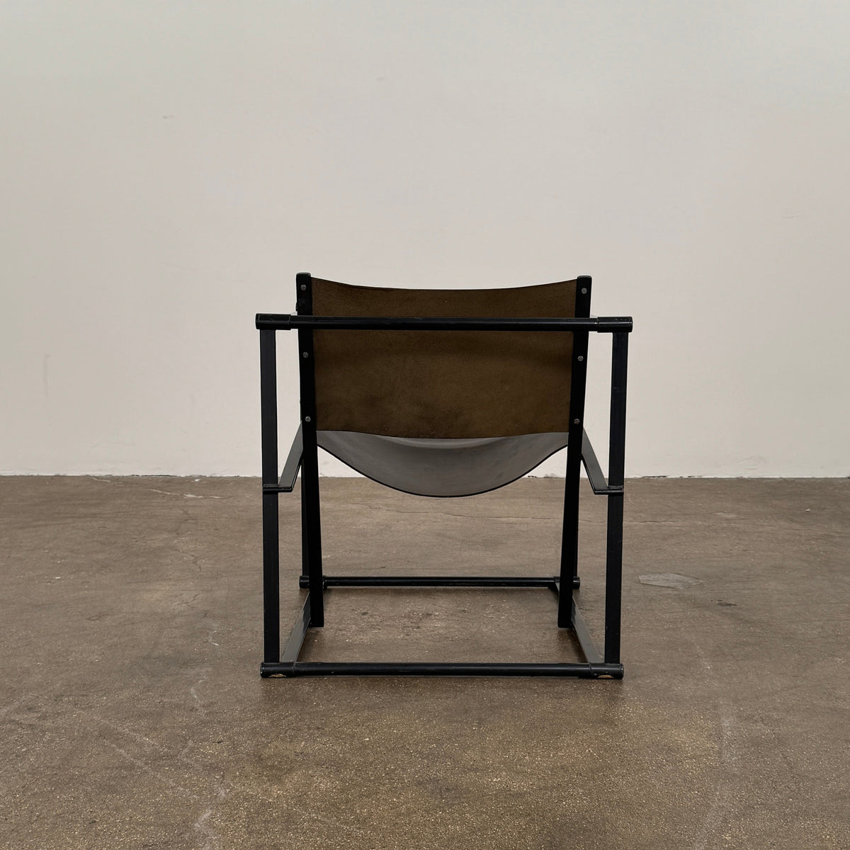Two black Vintage Pastoe FM62 Chairs by Pastoe, inspired by constructivist design, are placed on a tile floor in a spacious, minimal living room with large windows overlooking a pool and greenery outside.