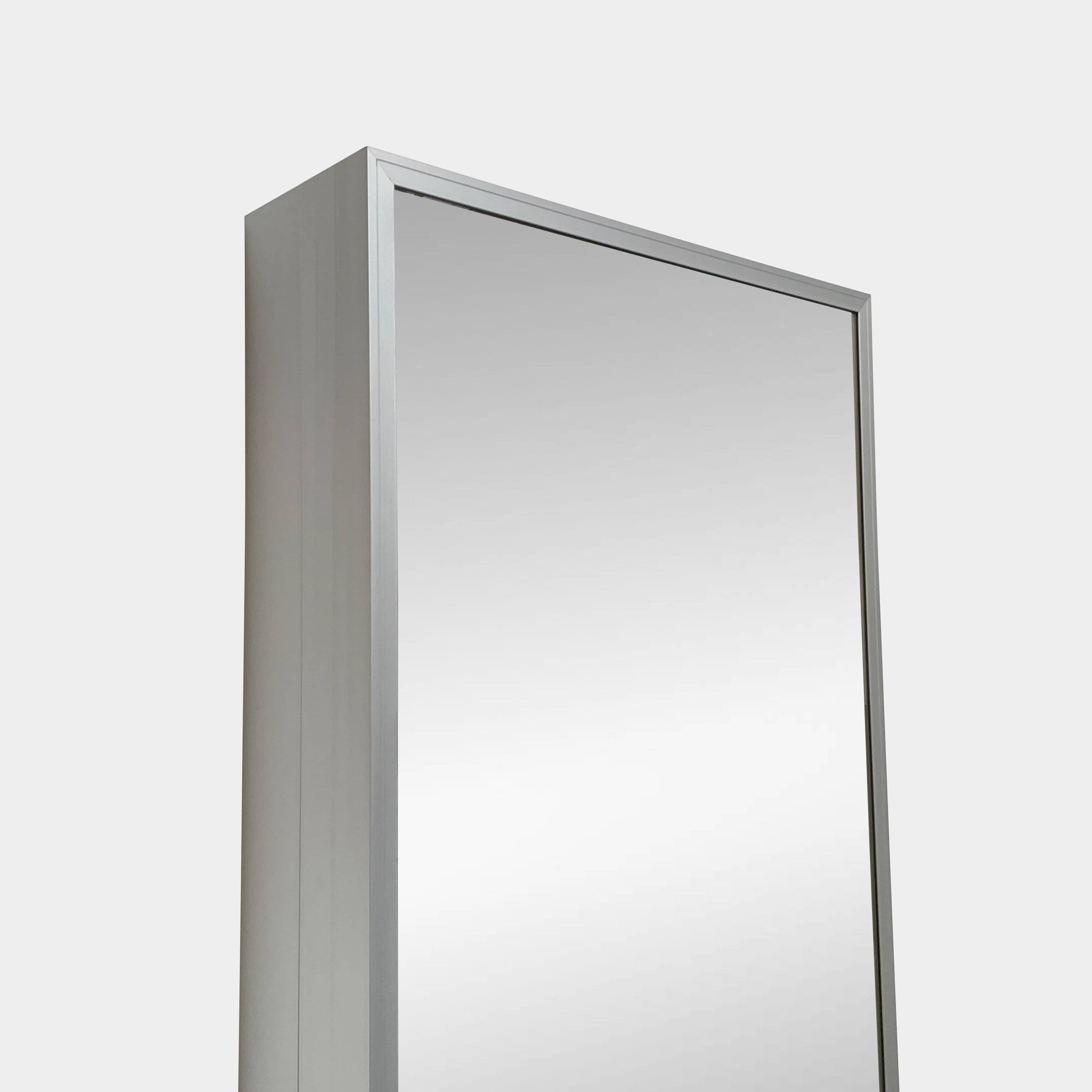 A Bellato Box Mirror Cabinet, featuring a rectangular, full-length design with a thin silver frame, stands elegantly against a plain light gray background.