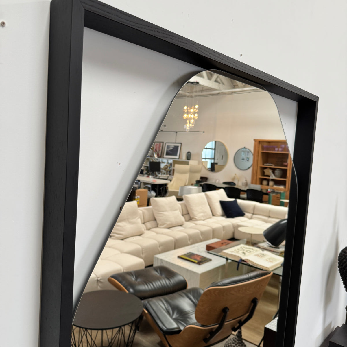 Rectangular wall mirror featuring a geometric, irregular octagonal silhouette set in a slim black metal frame against a minimalist backdrop—introducing the Ligne Roset Belize Mirror by Ligne Roset, an effortlessly modern statement piece for any space.