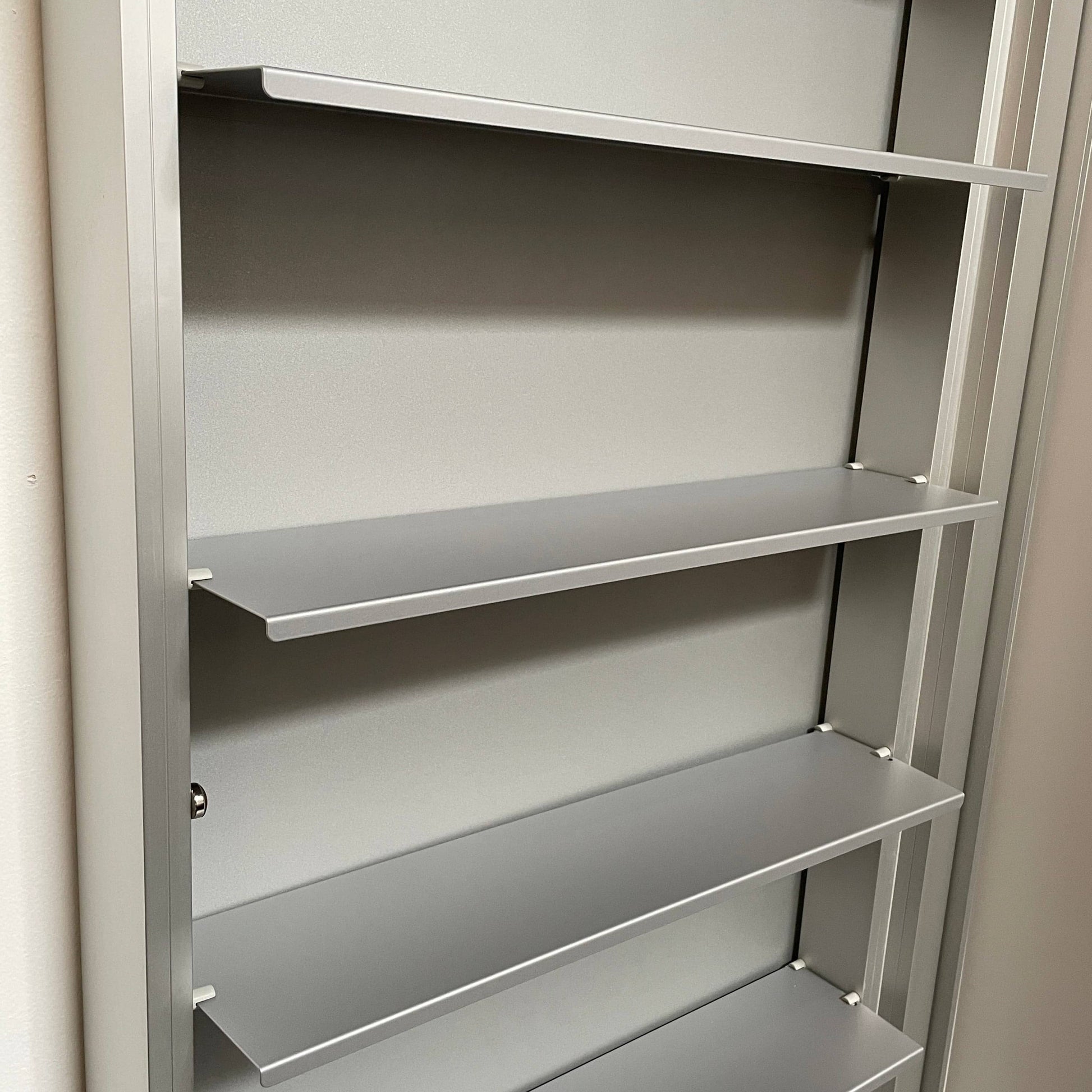 A Bellato Box Mirror Cabinet, featuring a rectangular, full-length design with a thin silver frame, stands elegantly against a plain light gray background.