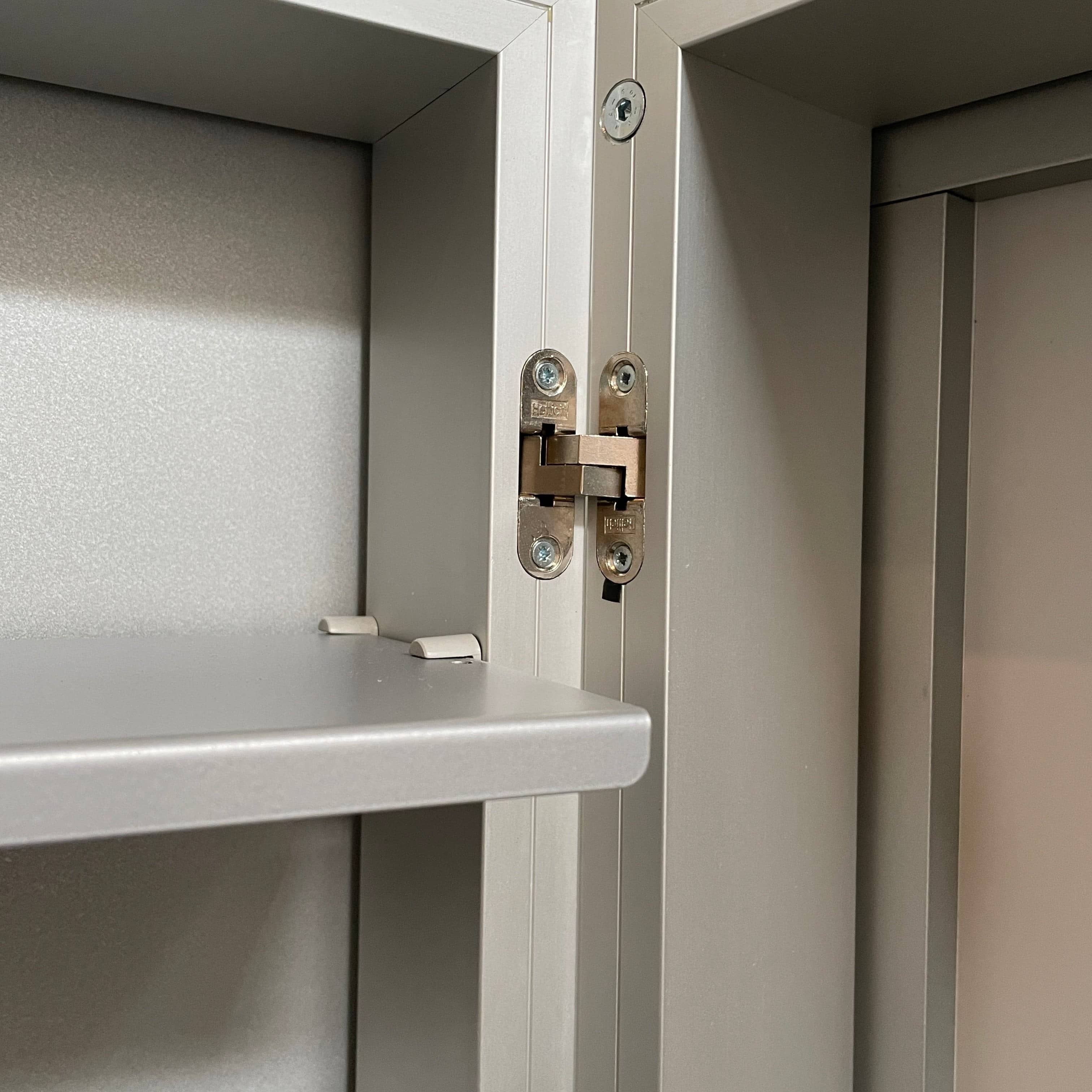 A Bellato Box Mirror Cabinet, featuring a rectangular, full-length design with a thin silver frame, stands elegantly against a plain light gray background.
