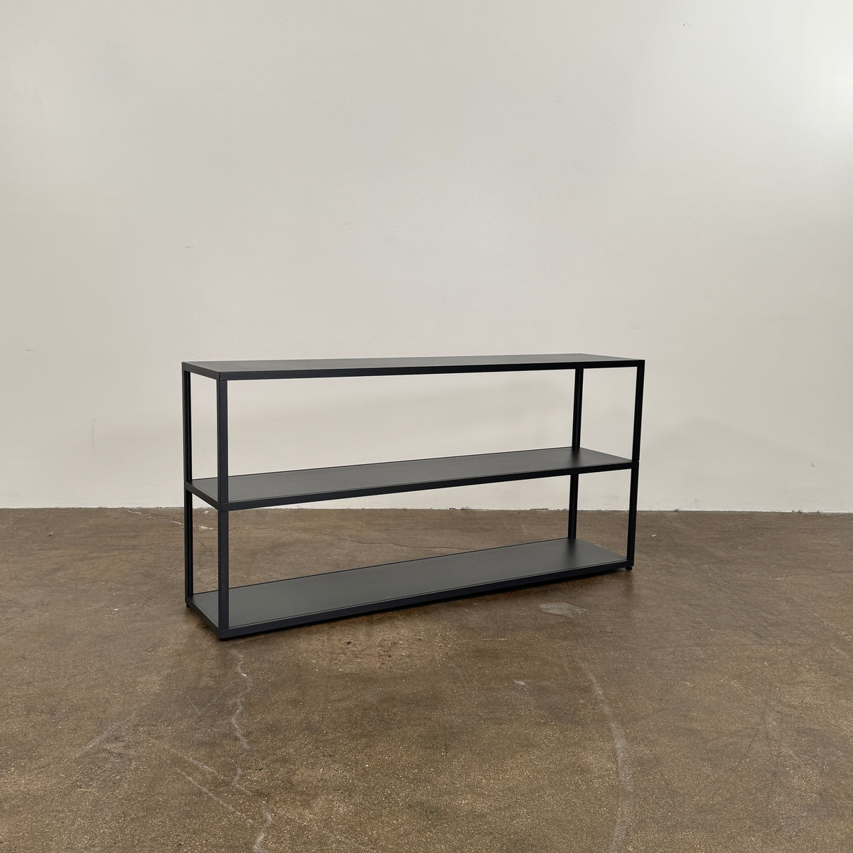 The Hay New Order System Shelves by Hay is a black, metal-framed, two-shelf open bookcase featuring a minimalist design inspired by Scandinavian aesthetics, shown against a plain white background.