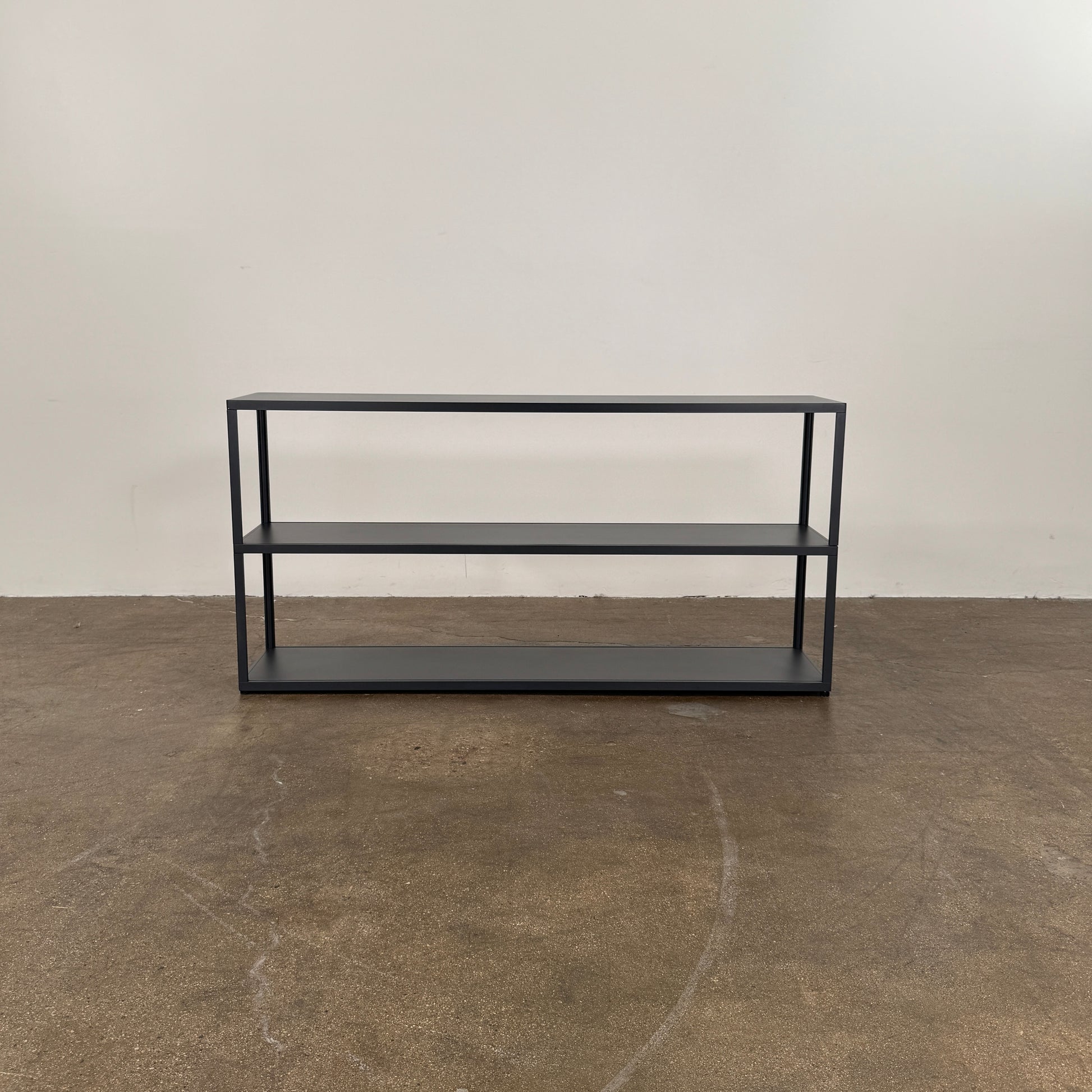 The Hay New Order System Shelves by Hay is a black, metal-framed, two-shelf open bookcase featuring a minimalist design inspired by Scandinavian aesthetics, shown against a plain white background.
