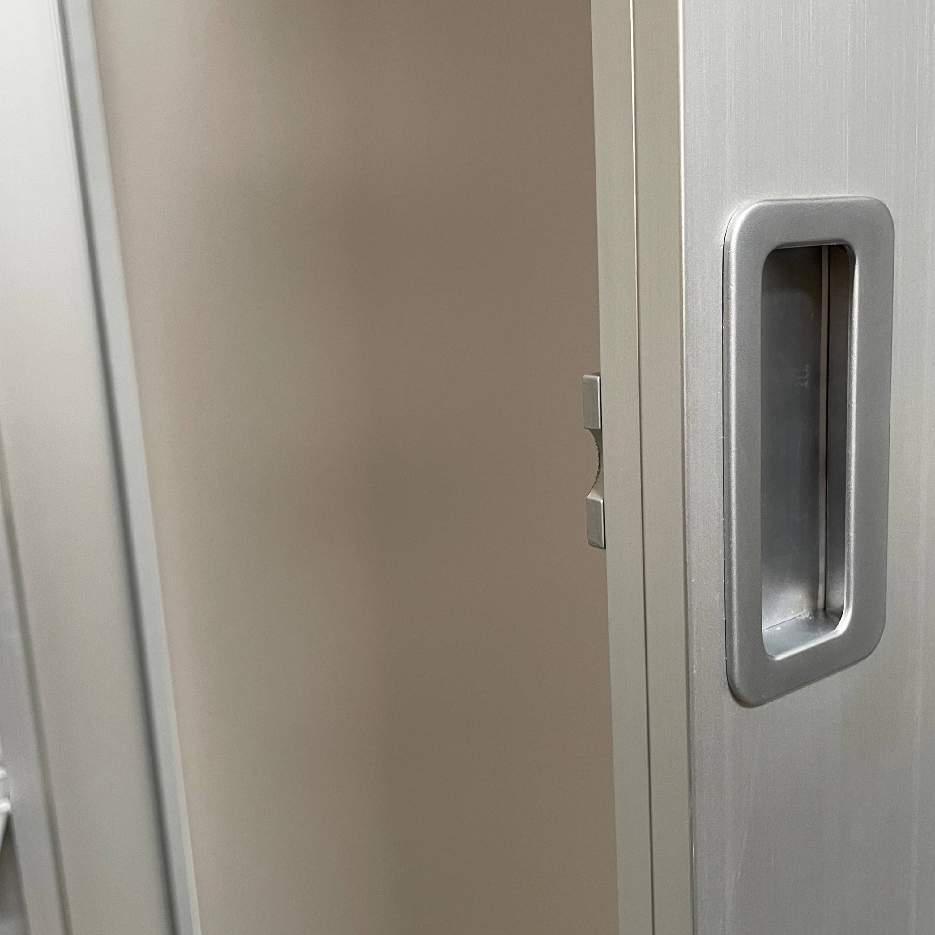 A Bellato Box Mirror Cabinet, featuring a rectangular, full-length design with a thin silver frame, stands elegantly against a plain light gray background.