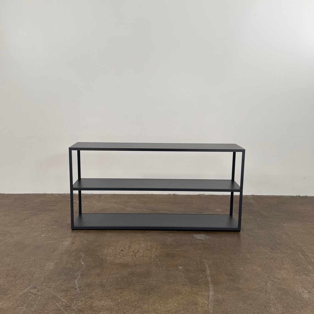 The Hay New Order System Shelves by Hay is a black, metal-framed, two-shelf open bookcase featuring a minimalist design inspired by Scandinavian aesthetics, shown against a plain white background.