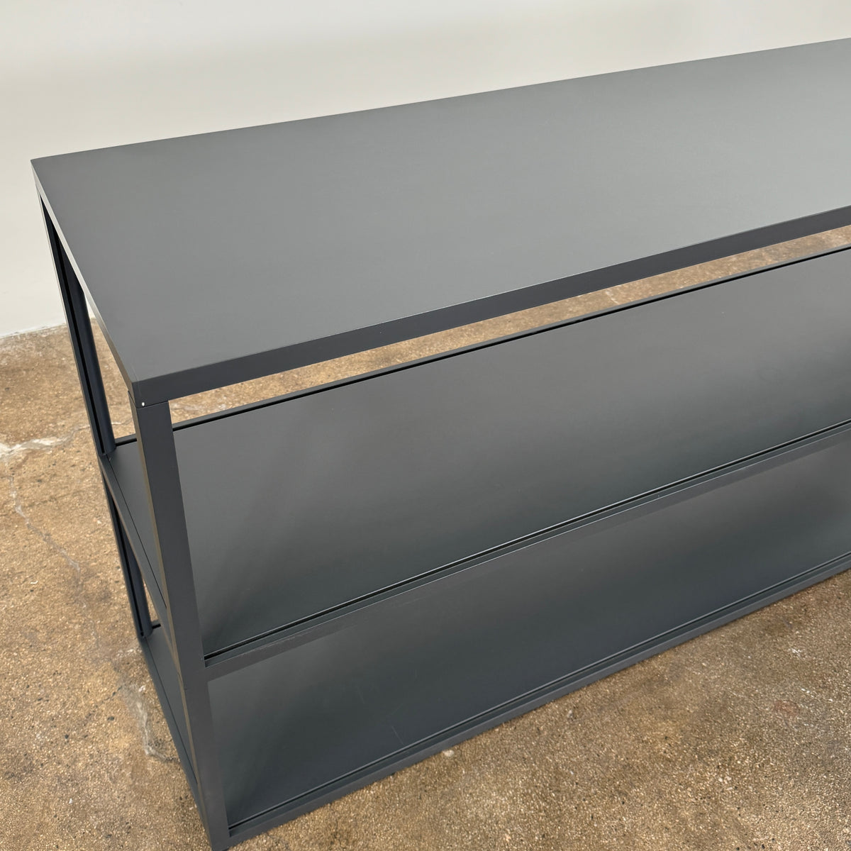 The Hay New Order System Shelves by Hay is a black, metal-framed, two-shelf open bookcase featuring a minimalist design inspired by Scandinavian aesthetics, shown against a plain white background.