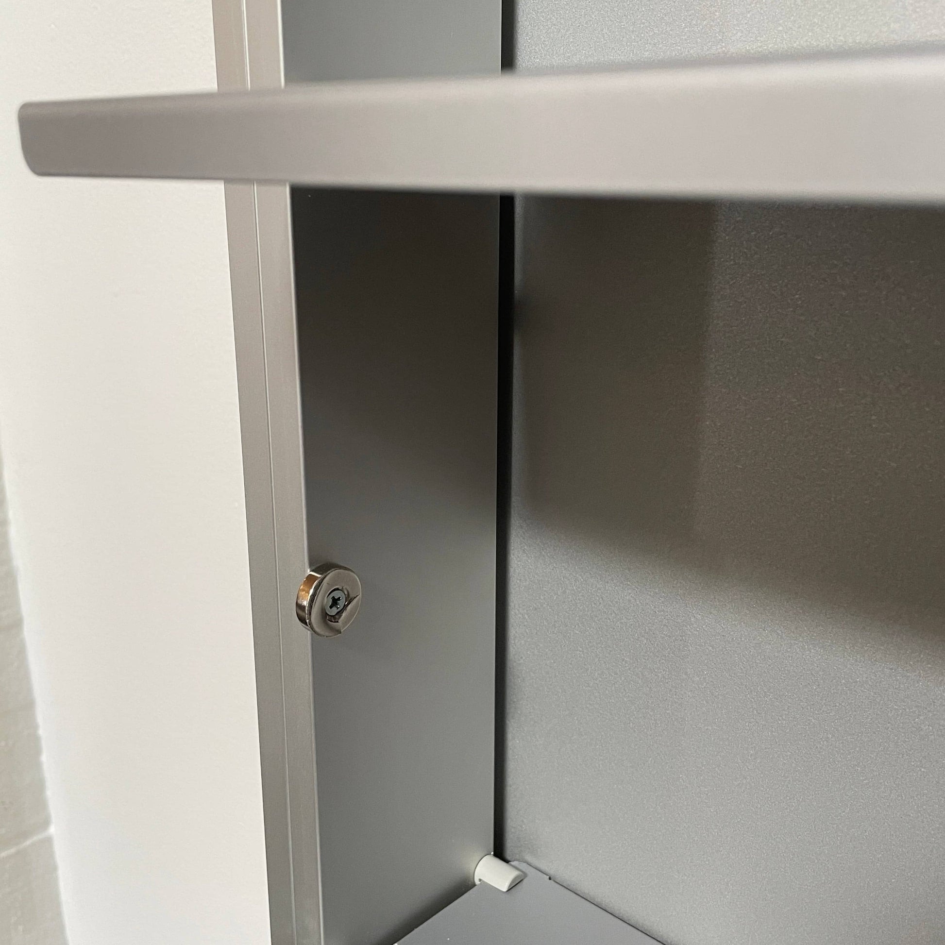 A Bellato Box Mirror Cabinet, featuring a rectangular, full-length design with a thin silver frame, stands elegantly against a plain light gray background.