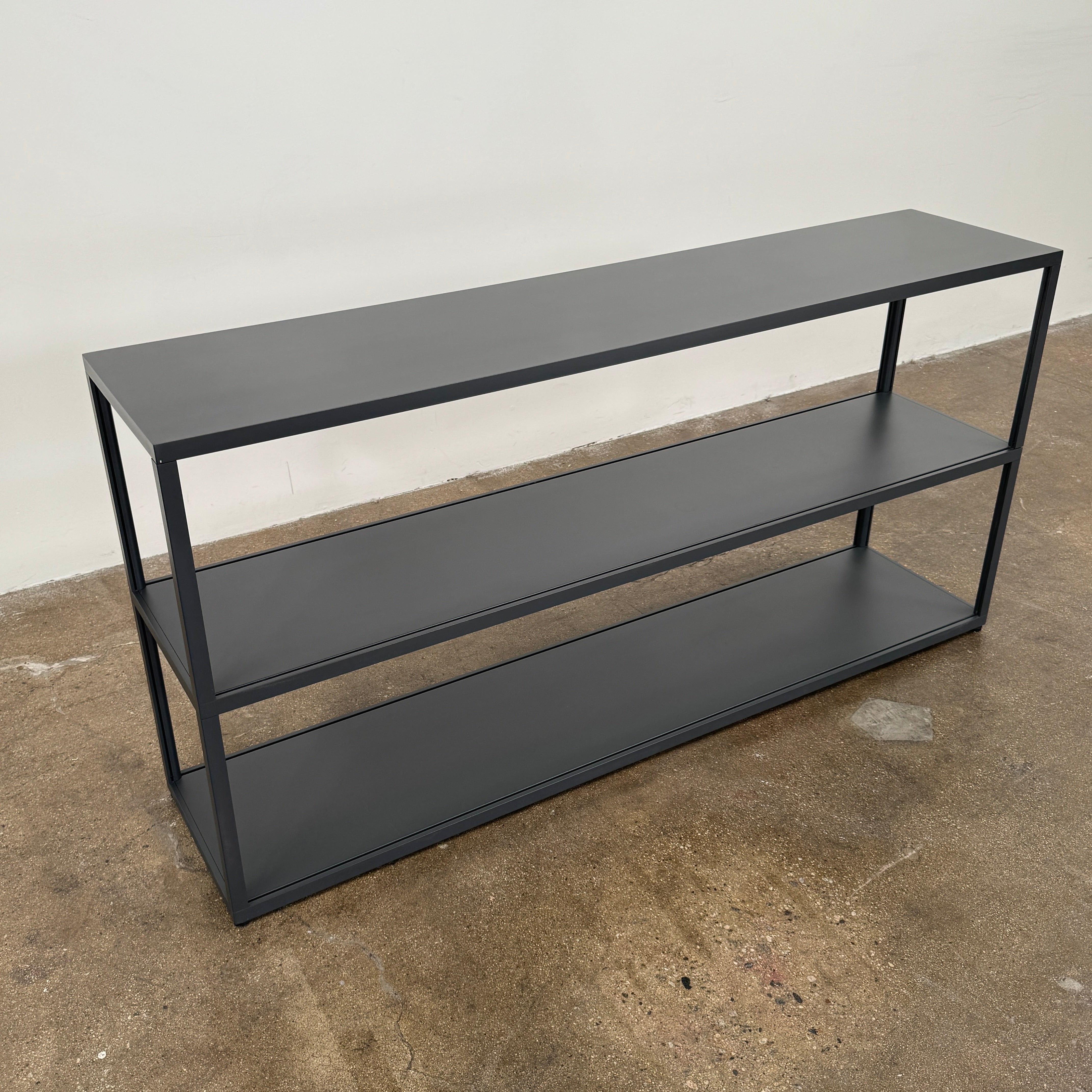 The Hay New Order System Shelves by Hay is a black, metal-framed, two-shelf open bookcase featuring a minimalist design inspired by Scandinavian aesthetics, shown against a plain white background.