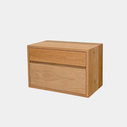 The Jenni Kayne Palms Nightstand Oak 30” by Jenni Kayne is a rectangular wooden drawer unit with a minimalist design, featuring one large lower drawer and one smaller upper drawer, showcased against a plain white background—a piece that perfectly captures the understated elegance of an oak nightstand, making it an ideal choice as a refined bedside table.