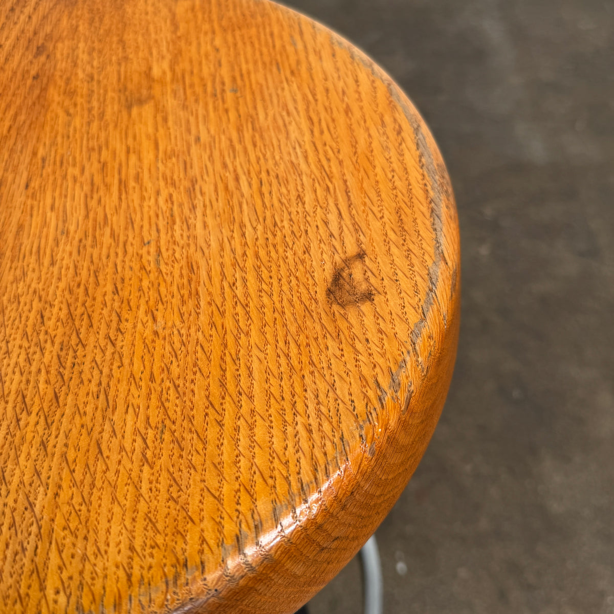 A set of three Vintage Stools in the style of Jean Prouve by Vintage, featuring black metal frames, round brown wooden seats, and silver footrests, are arranged in a row against a plain white background, evoking a classic mid-century design.