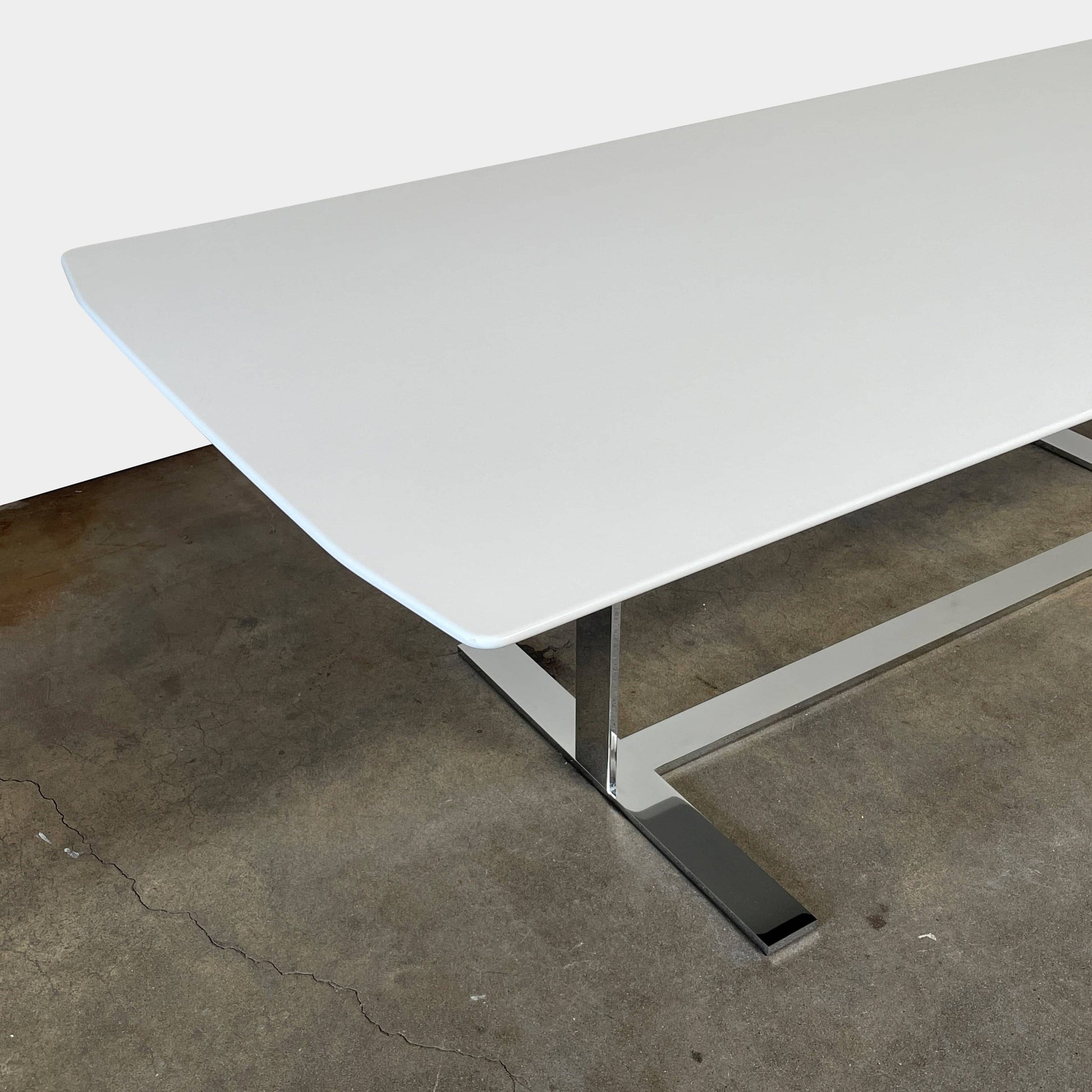 A minimalist rectangular B&B Italia Eileen White Dining Table featuring a sophisticated T-shaped metal base on a plain white background.