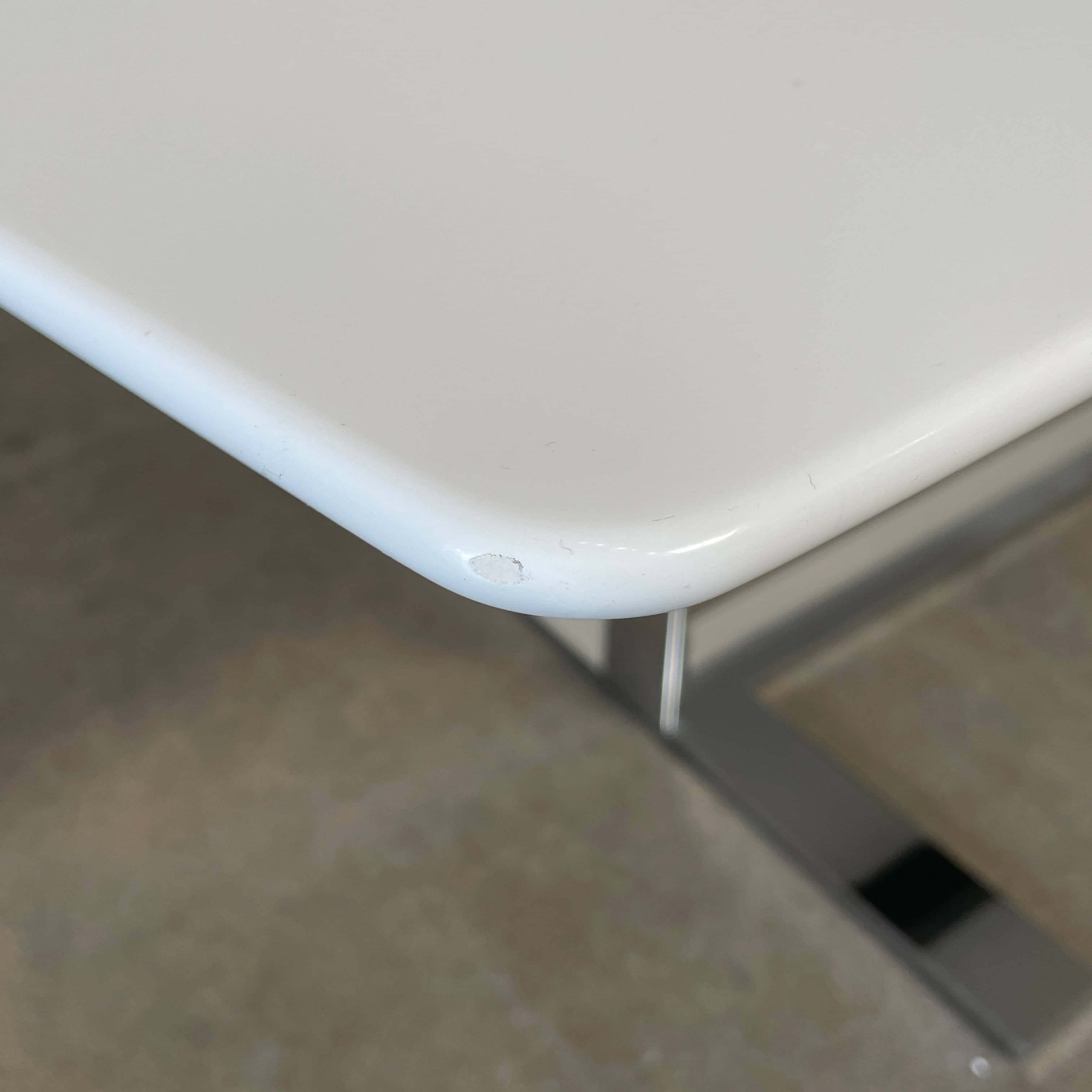 A minimalist rectangular B&B Italia Eileen White Dining Table featuring a sophisticated T-shaped metal base on a plain white background.