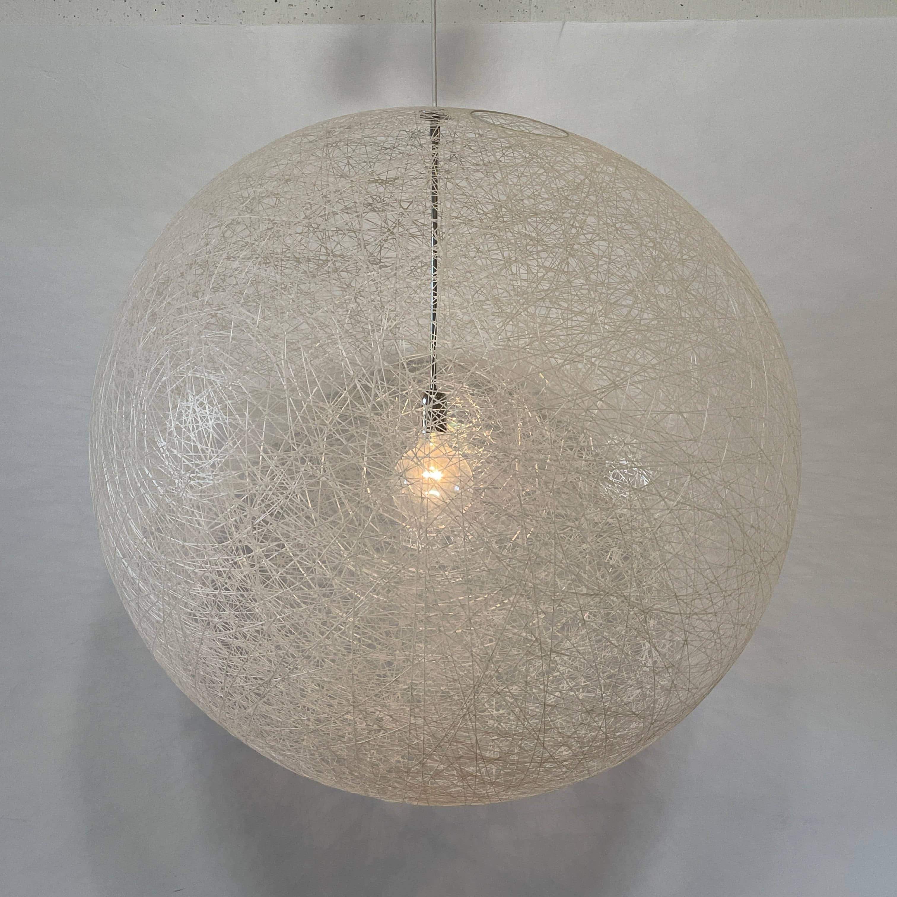 A Moooi Random Pendant suspension light with a white ball, reminiscent of the Moooi Random design, hanging from a light fixture.