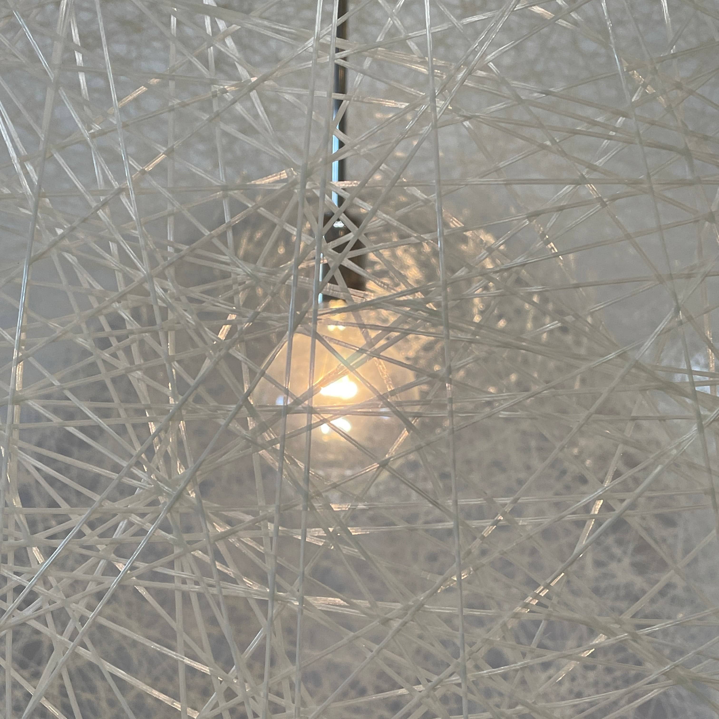 A Moooi Random Pendant suspension light with a white ball, reminiscent of the Moooi Random design, hanging from a light fixture.