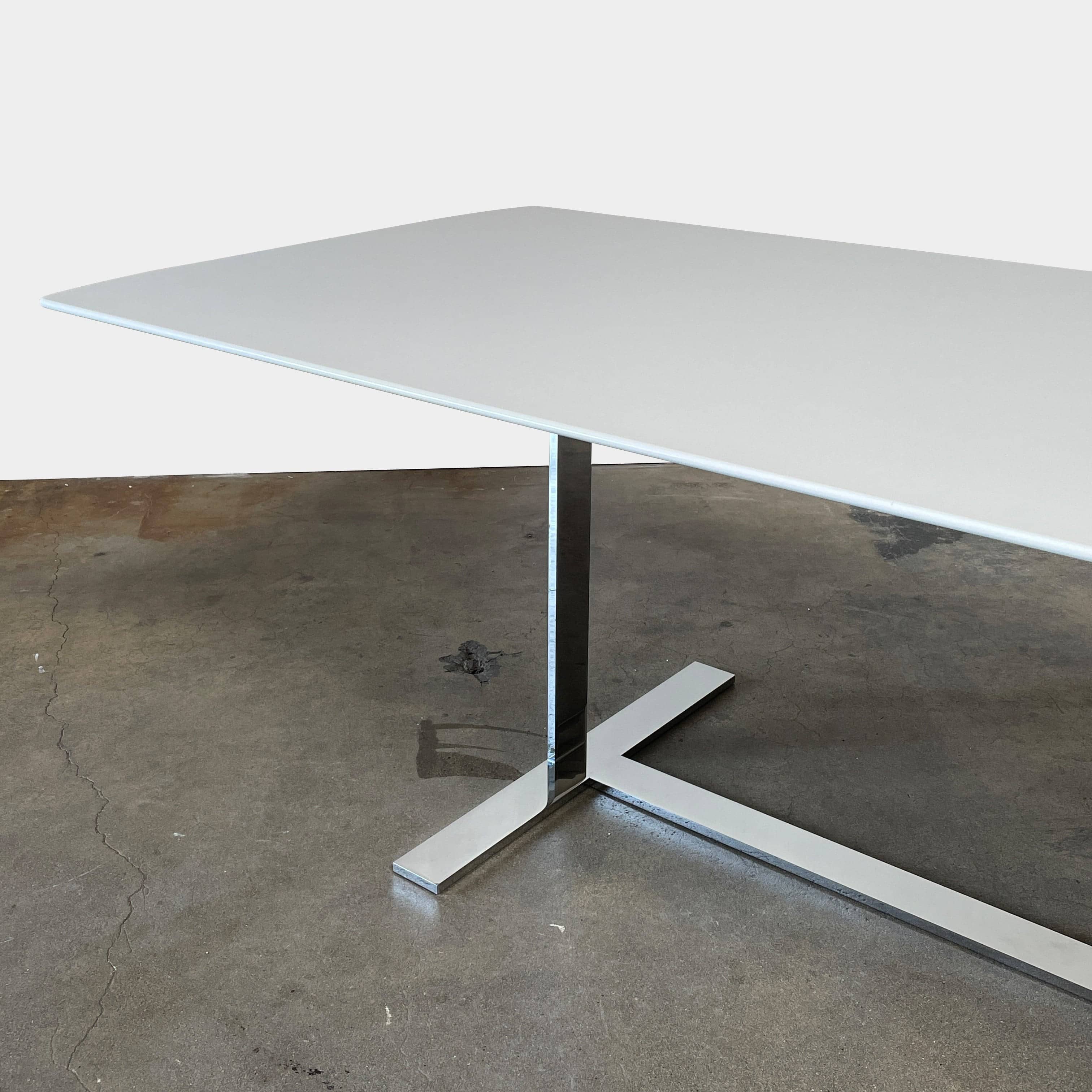 A minimalist rectangular B&B Italia Eileen White Dining Table featuring a sophisticated T-shaped metal base on a plain white background.