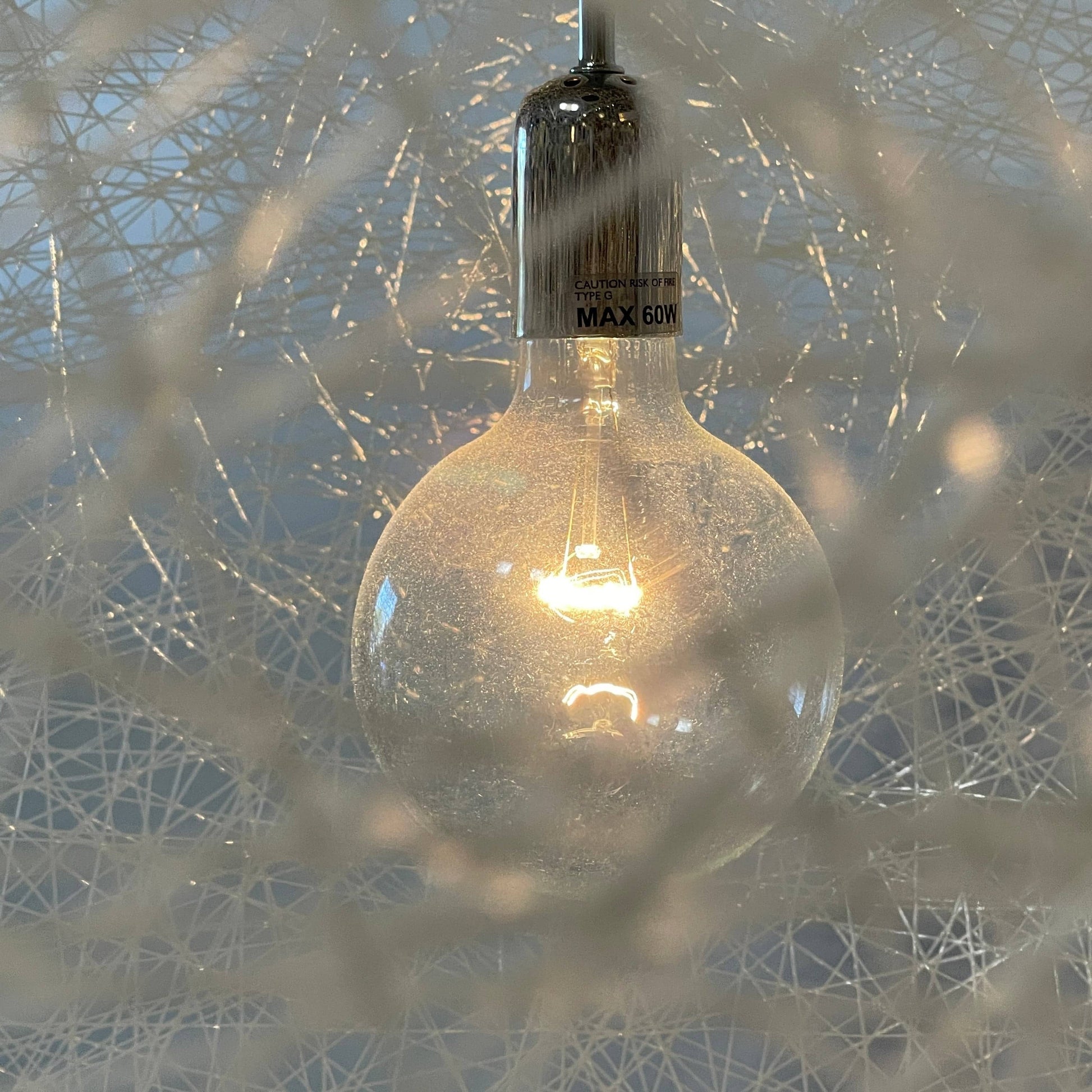 A Moooi Random Pendant suspension light with a white ball, reminiscent of the Moooi Random design, hanging from a light fixture.