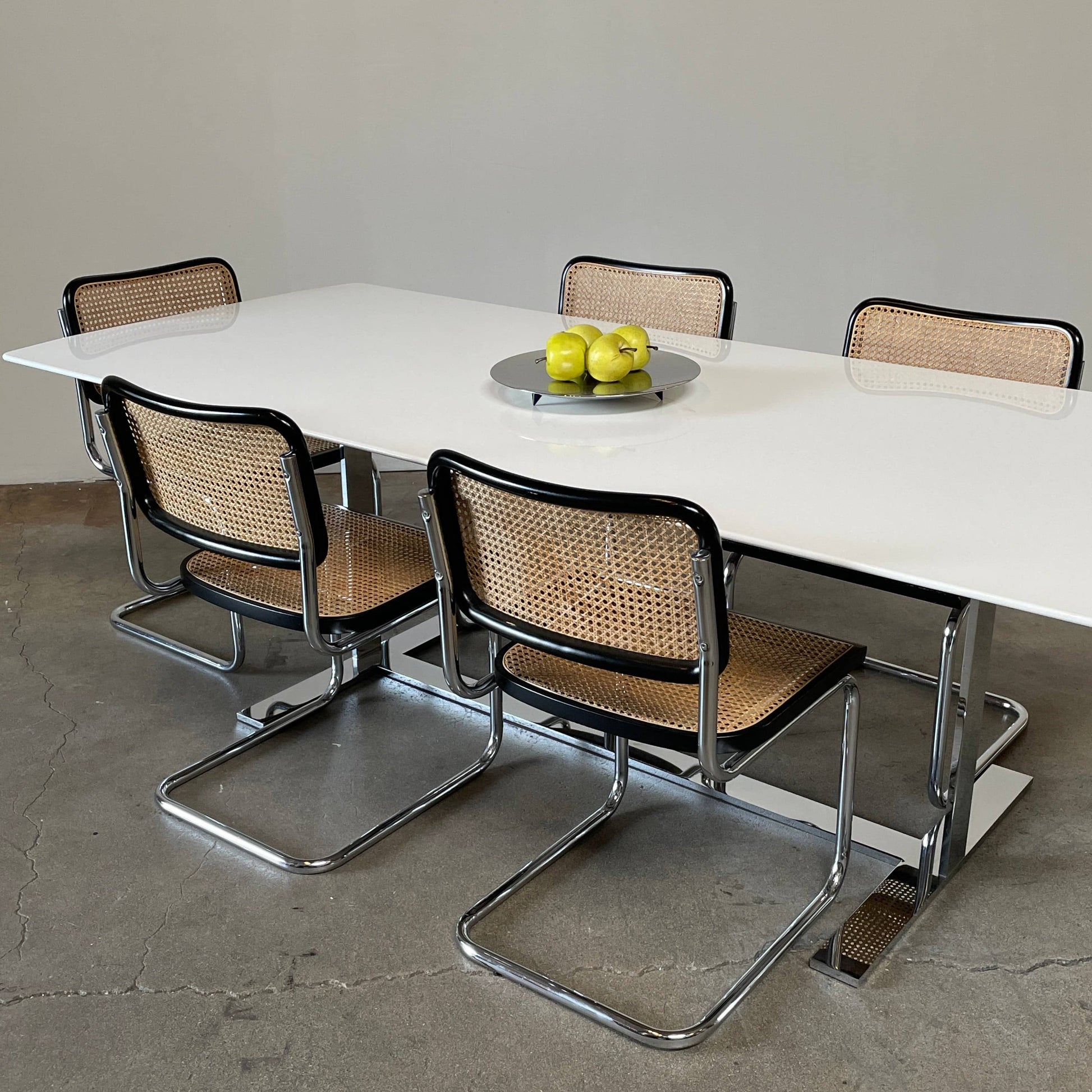 A minimalist rectangular B&B Italia Eileen White Dining Table featuring a sophisticated T-shaped metal base on a plain white background.