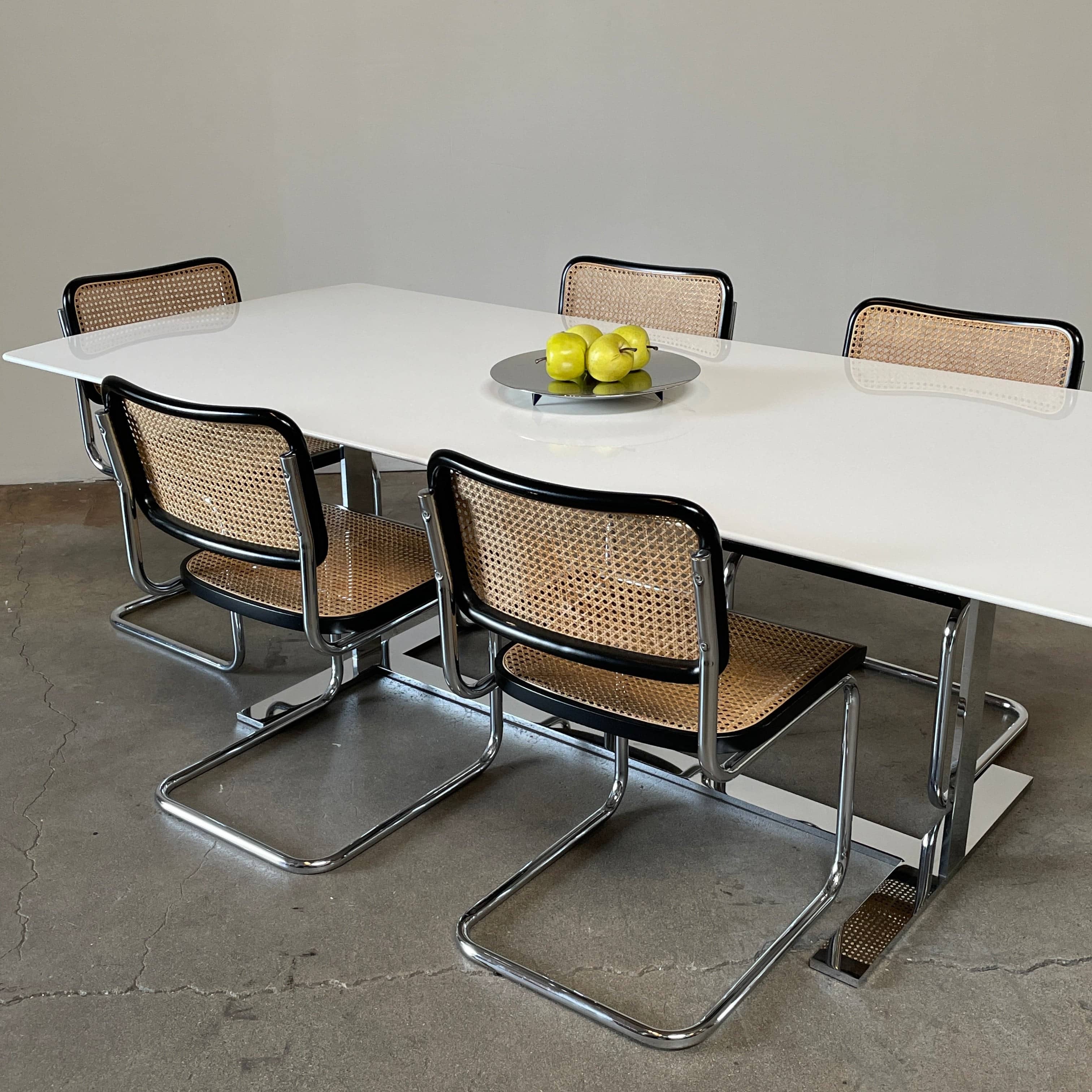 A minimalist rectangular B&B Italia Eileen White Dining Table featuring a sophisticated T-shaped metal base on a plain white background.