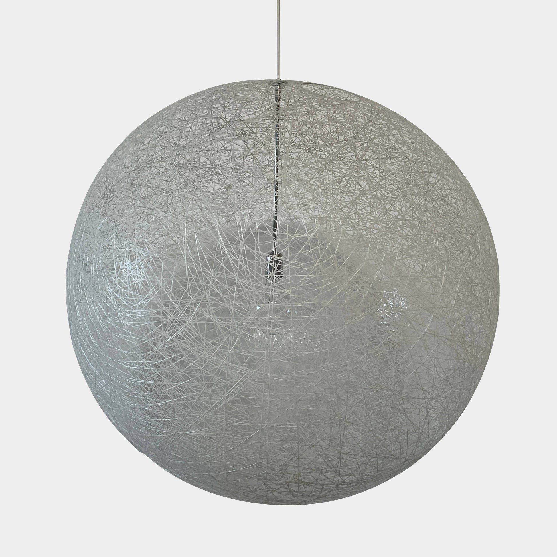 A Moooi Random Pendant suspension light with a white ball, reminiscent of the Moooi Random design, hanging from a light fixture.