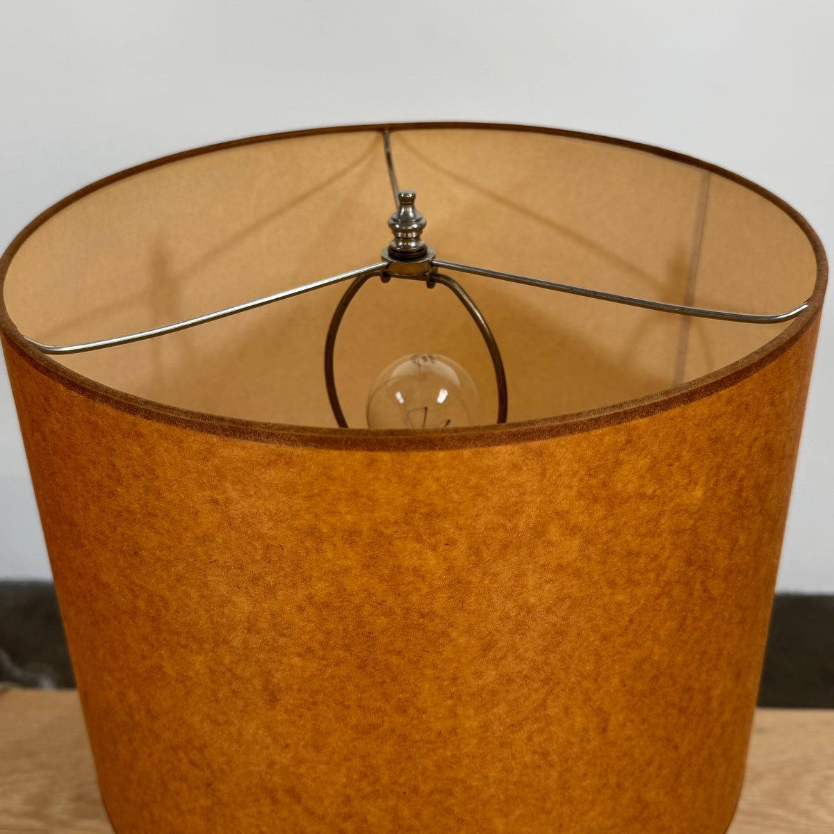 Two Shelter Brasilia Lamp by Modern Resale with textured white bases and orange cylindrical shades are displayed on a beige stone surface against a gray background.