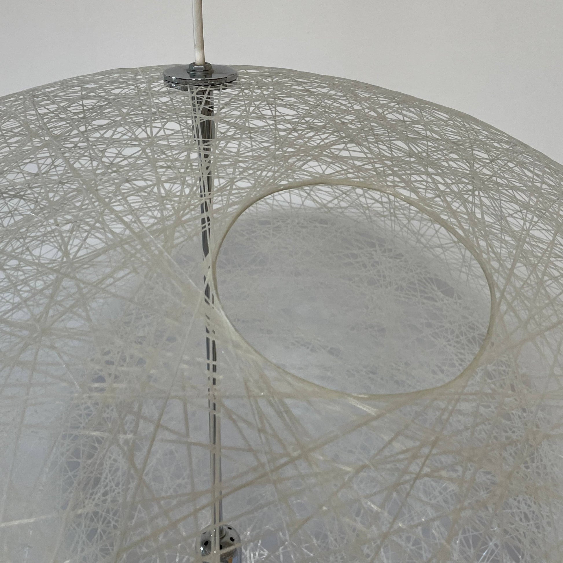 A Moooi Random Pendant suspension light with a white ball, reminiscent of the Moooi Random design, hanging from a light fixture.