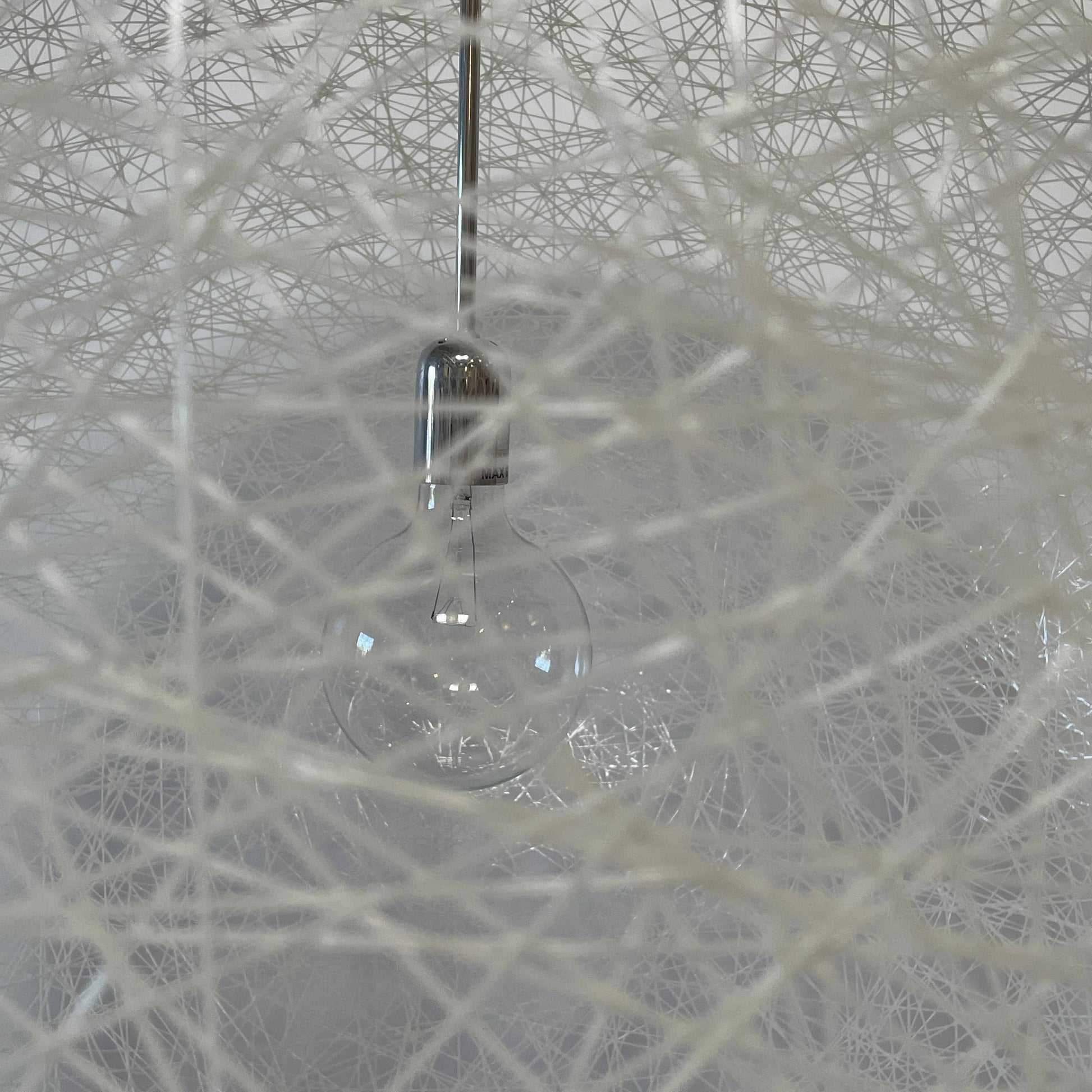 A Moooi Random Pendant suspension light with a white ball, reminiscent of the Moooi Random design, hanging from a light fixture.