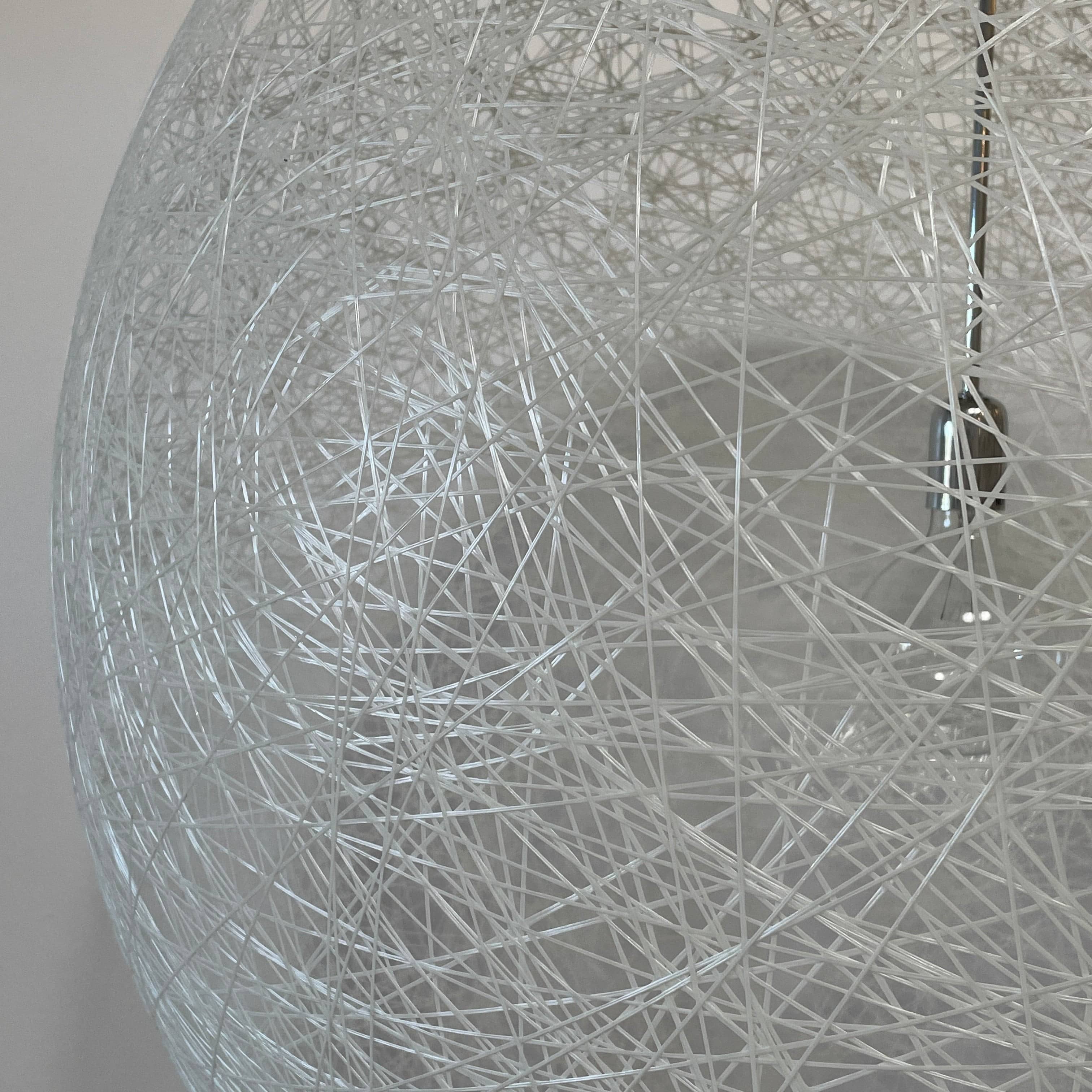 A Moooi Random Pendant suspension light with a white ball, reminiscent of the Moooi Random design, hanging from a light fixture.