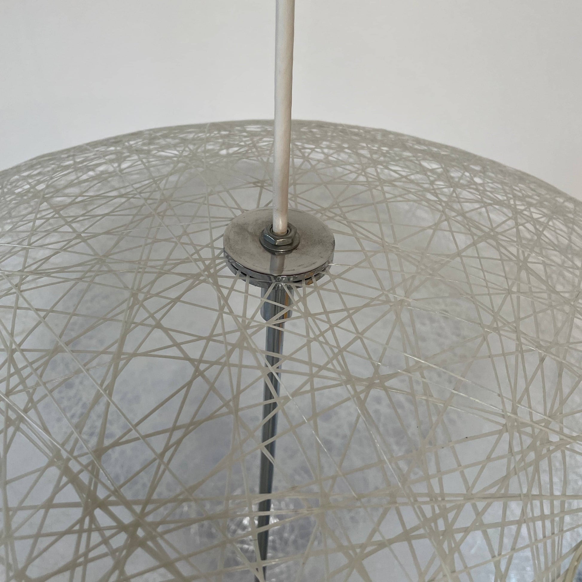 A Moooi Random Pendant suspension light with a white ball, reminiscent of the Moooi Random design, hanging from a light fixture.