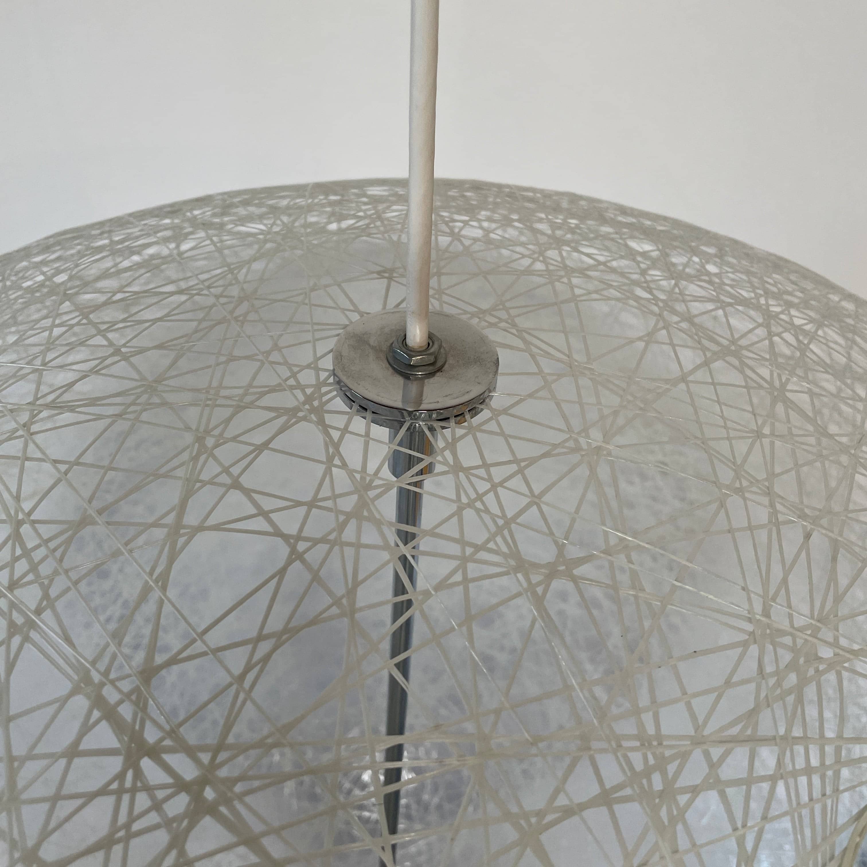 A Moooi Random Pendant suspension light with a white ball, reminiscent of the Moooi Random design, hanging from a light fixture.