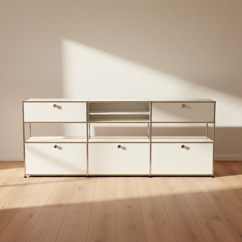 A USM Haller Storage Cabinet by USM, finished in minimal white, stands on a plain concrete floor against a light-colored wall. The modular cabinet features six closed compartments, two open shelves, and a sturdy metal frame.