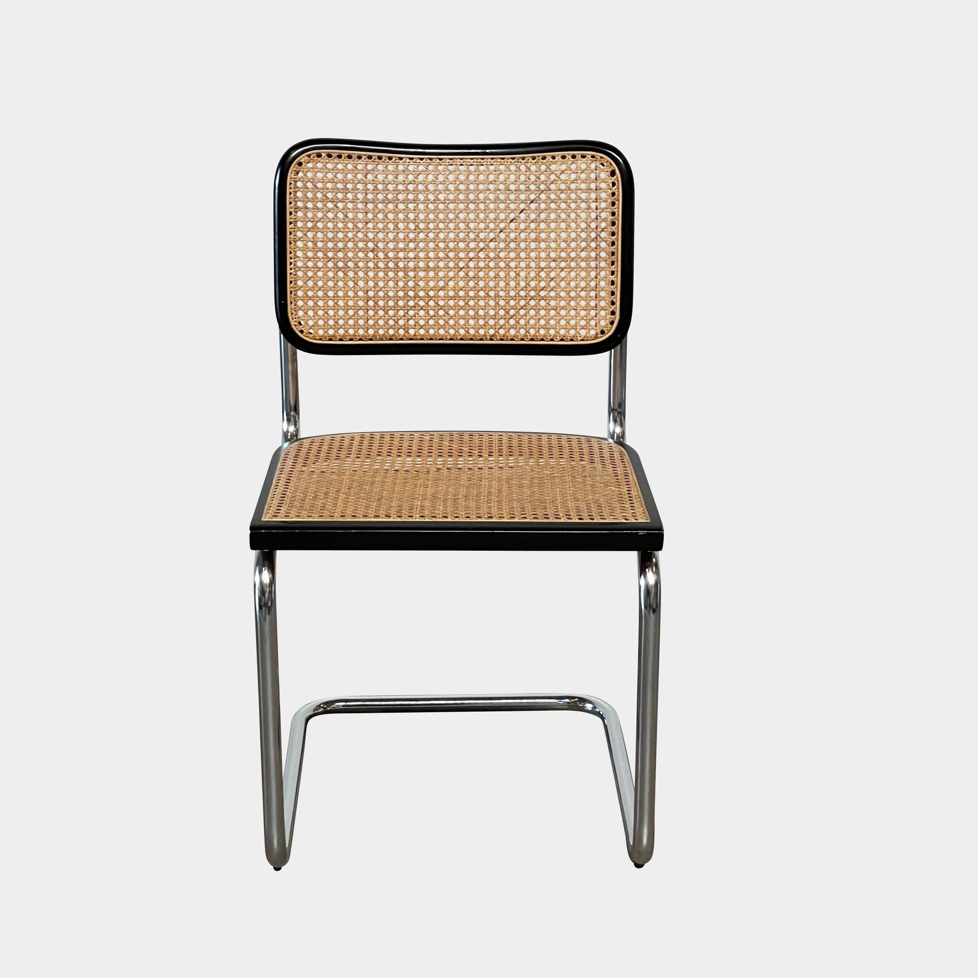 The Vintage Marcel Breuers Cesca Dining Chair showcases a chrome tubular steel frame with black edges and a woven cane seat and backrest, displayed against a plain white background.