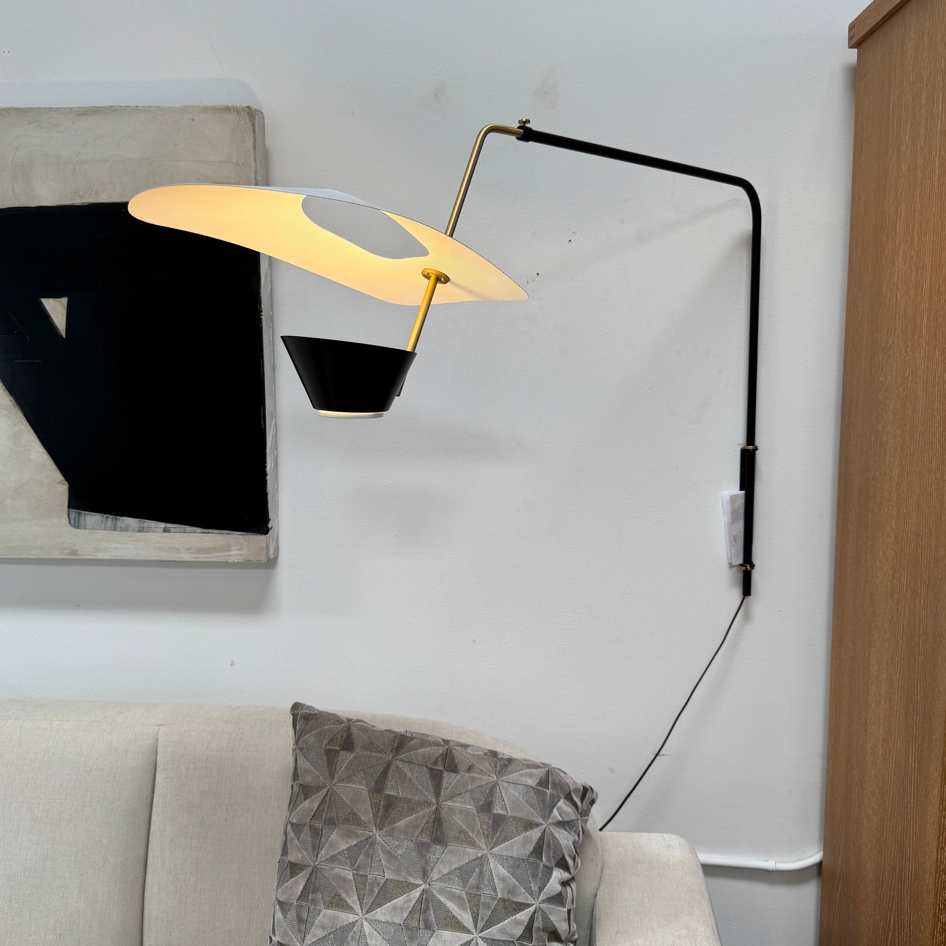 The Sammode G25 Wall lamp by Modern Resale features a black and white design, mounted above a light wood cabinet in a room with exposed ceiling beams.