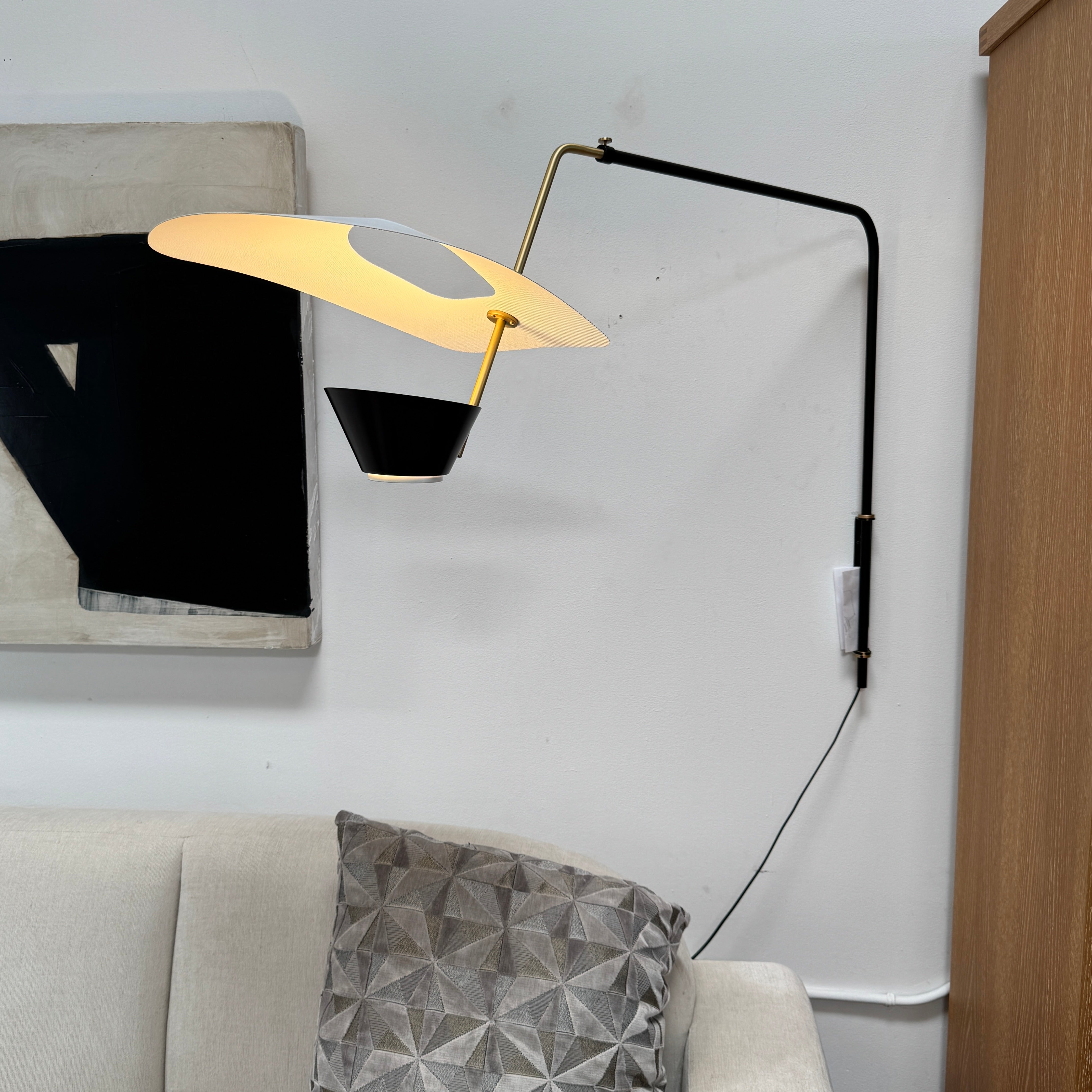 The Sammode G25 Wall lamp by Modern Resale features a black and white design, mounted above a light wood cabinet in a room with exposed ceiling beams.