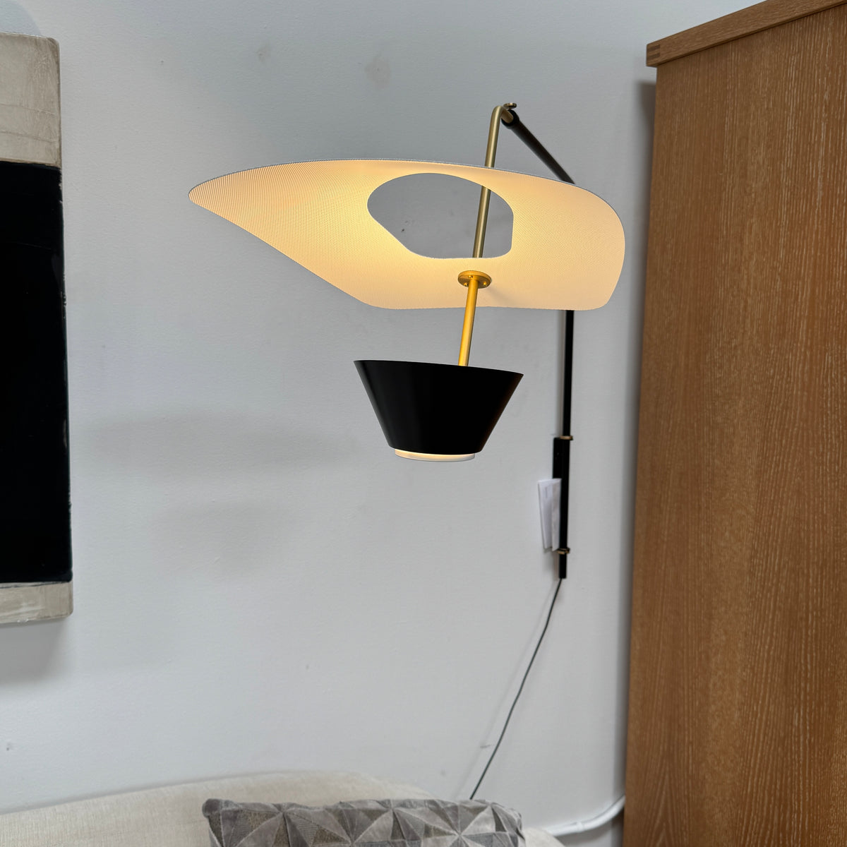 The Sammode G25 Wall lamp by Modern Resale features a black and white design, mounted above a light wood cabinet in a room with exposed ceiling beams.