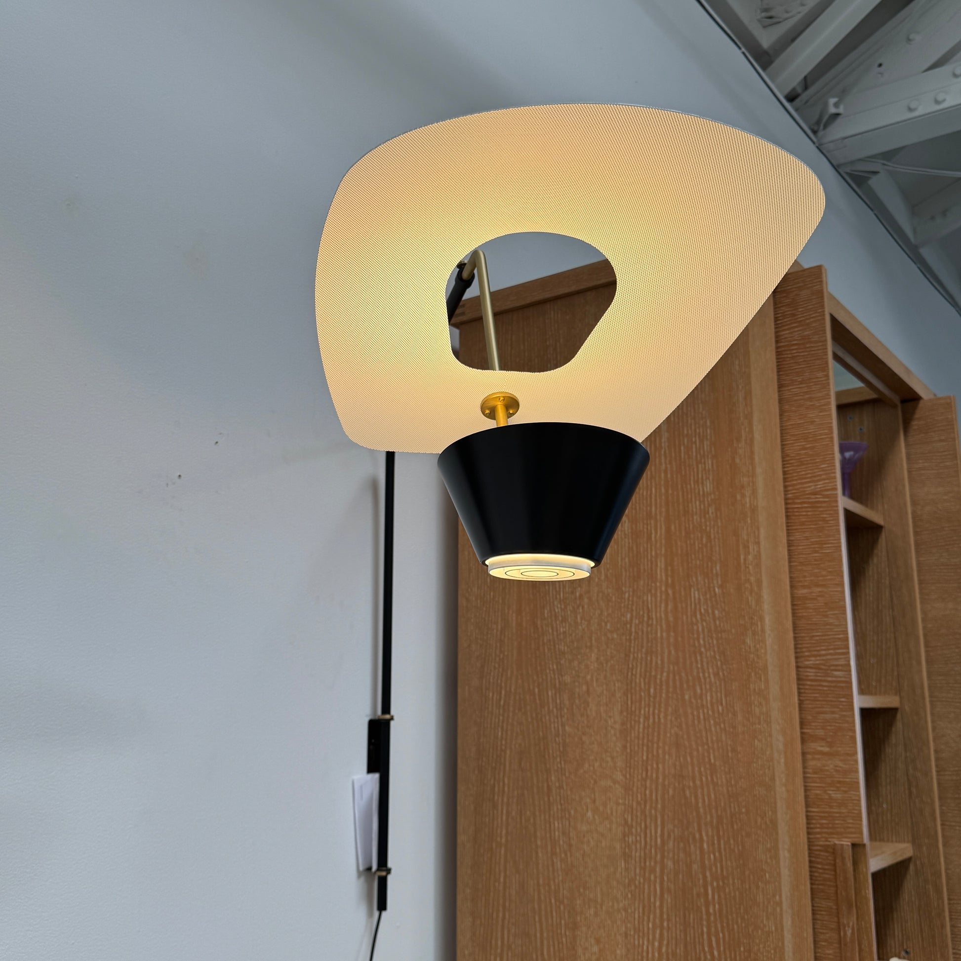 The Sammode G25 Wall lamp by Modern Resale features a black and white design, mounted above a light wood cabinet in a room with exposed ceiling beams.