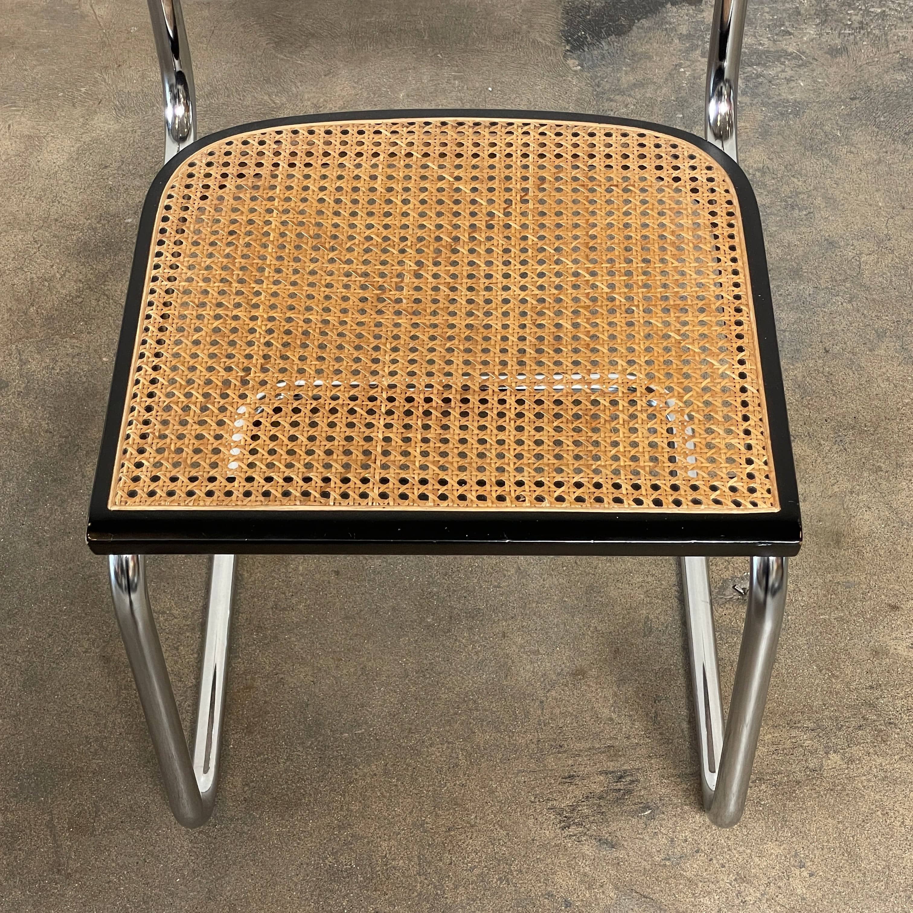 The Vintage Marcel Breuers Cesca Dining Chair showcases a chrome tubular steel frame with black edges and a woven cane seat and backrest, displayed against a plain white background.