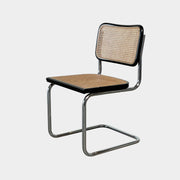 The Vintage Marcel Breuers Cesca Dining Chair showcases a chrome tubular steel frame with black edges and a woven cane seat and backrest, displayed against a plain white background.