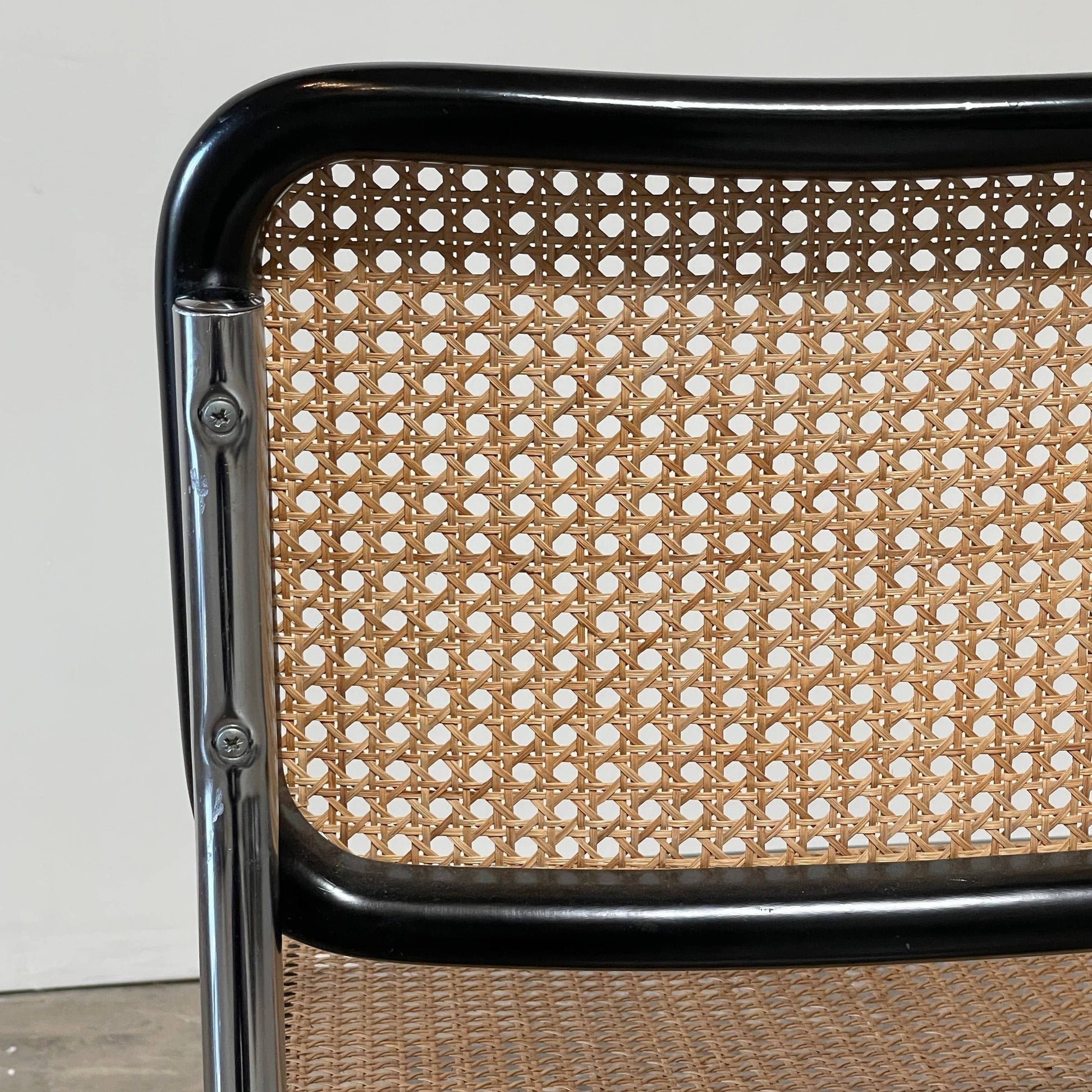 The Vintage Marcel Breuers Cesca Dining Chair showcases a chrome tubular steel frame with black edges and a woven cane seat and backrest, displayed against a plain white background.