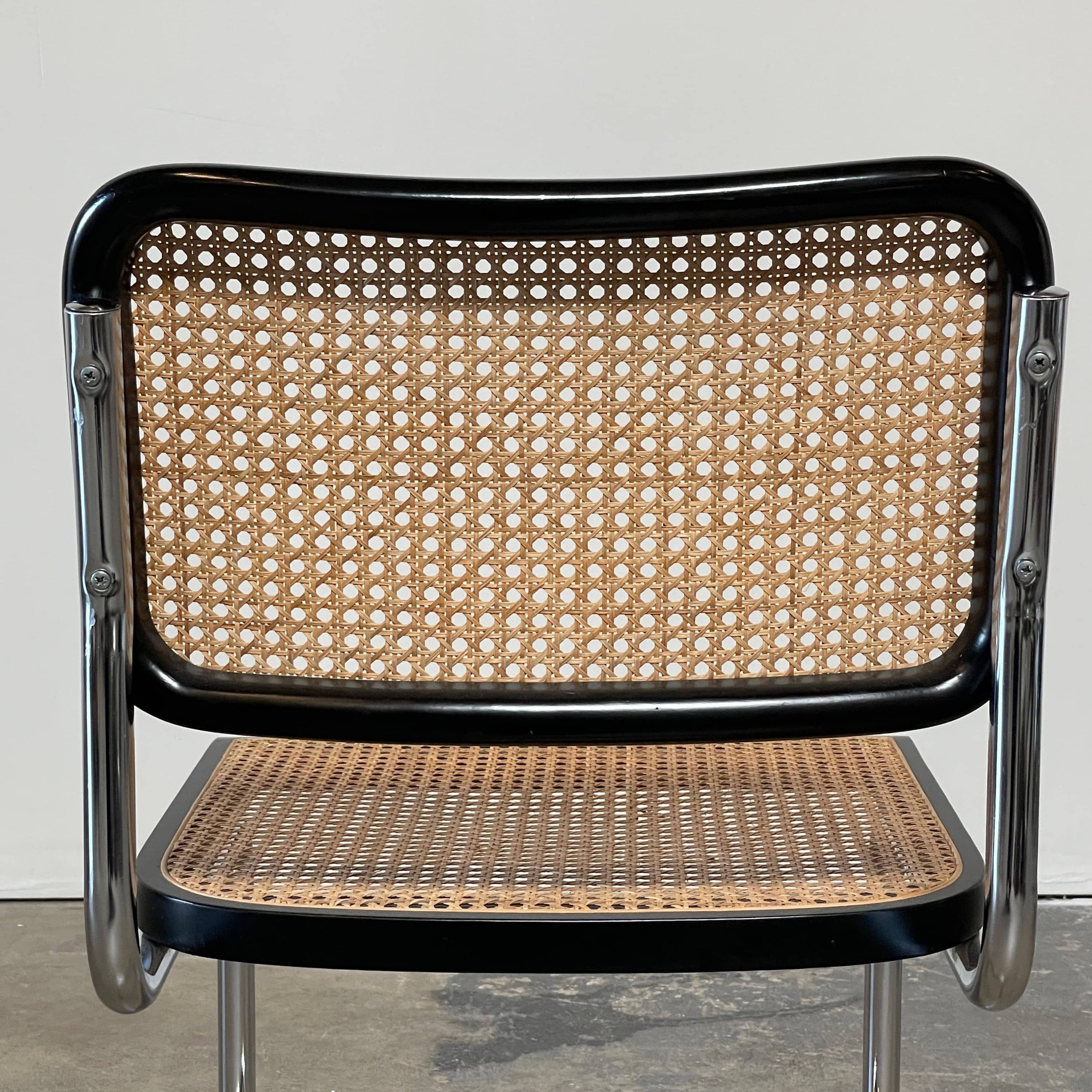 The Vintage Marcel Breuers Cesca Dining Chair showcases a chrome tubular steel frame with black edges and a woven cane seat and backrest, displayed against a plain white background.