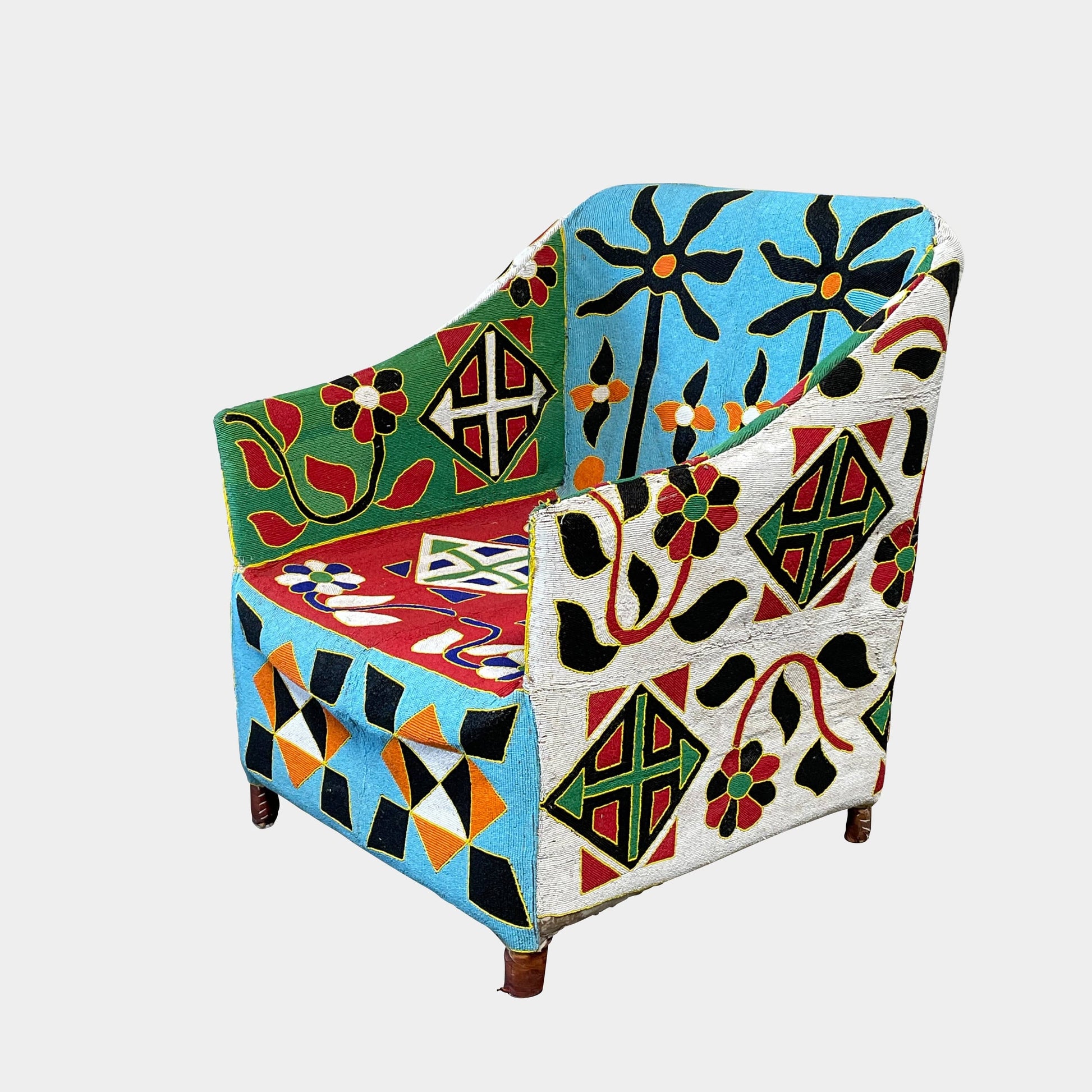 The Handmade Hand Beaded African Yoruba Chair (on hold) features a high backrest, wooden legs, and vibrant upholstery with multicolored geometric and floral patterns inspired by West African artistry.