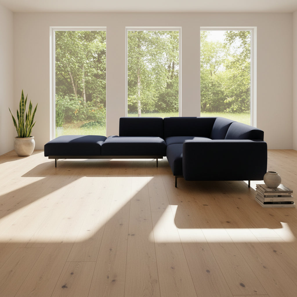 The Muuto Outline 3 Piece Sectional Sofa by Muuto features a dark blue fabric upholstery in a sleek, L-shaped design with low backrests and black legs, echoing the clean lines of contemporary architecture. The sectional stands out beautifully against a plain white background.