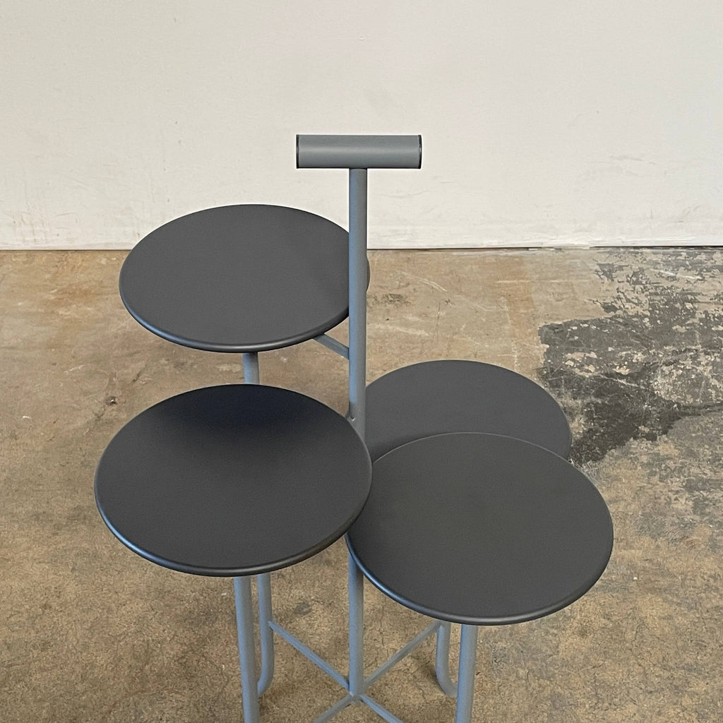 A black metal Four-Tier Accent Table with four trays on it by Unknown.