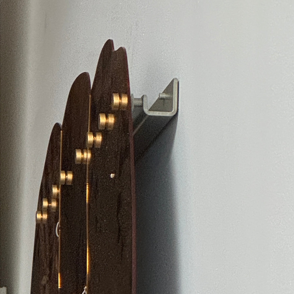The Edra Miraggio Mirror by Edra features irregular, gold-toned metal panels with visible fasteners, mounted on a white background to highlight its artisanal craftsmanship.