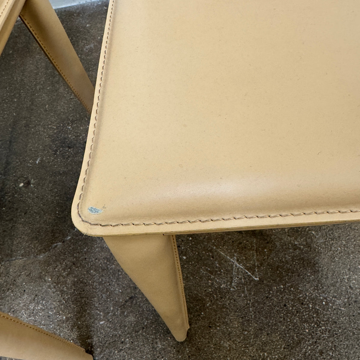 Eight light-tan Frag Bottega leather dining chairs arranged in two rows.