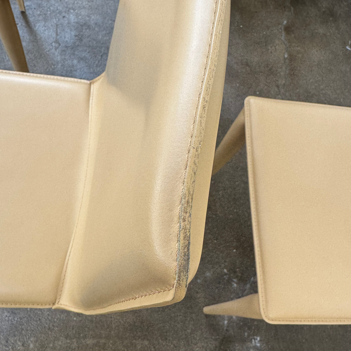 Eight light-tan Frag Bottega leather dining chairs arranged in two rows.